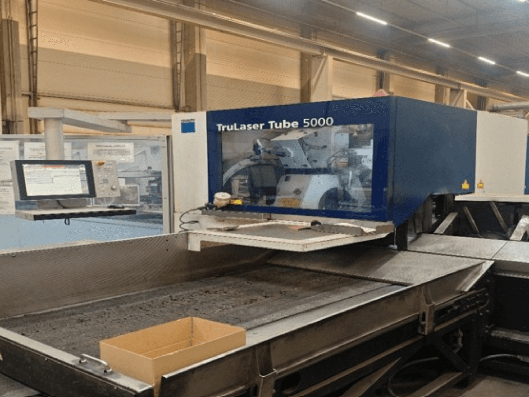 TRUMPF TruLaser Tube 5000 in a front view, showcasing the control panel and cutting area for precise tube cutting operations.