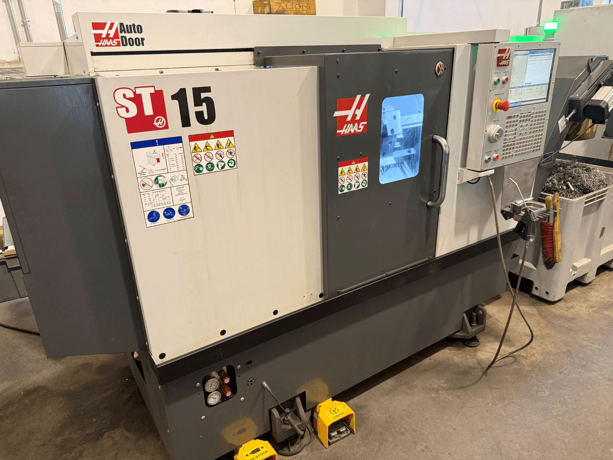 HAAS ST 15 horizontal turning machine, front view showcasing control panel, auto door, and visible technical indicators.