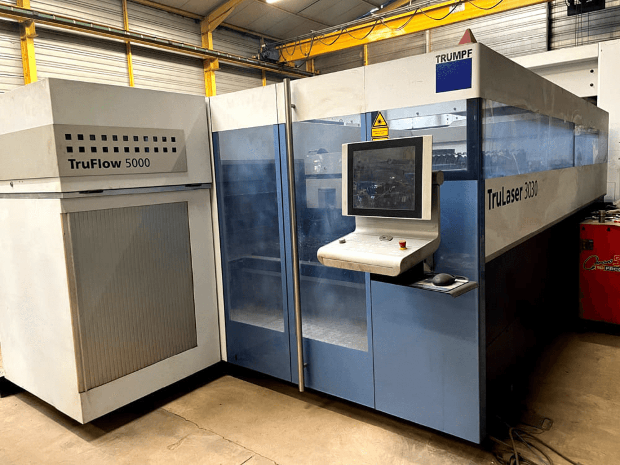 TRUMPF TruLaser 3030 CO2 laser cutting machine in front view, featuring a control panel and adjacent TruFlow 5000 unit.
