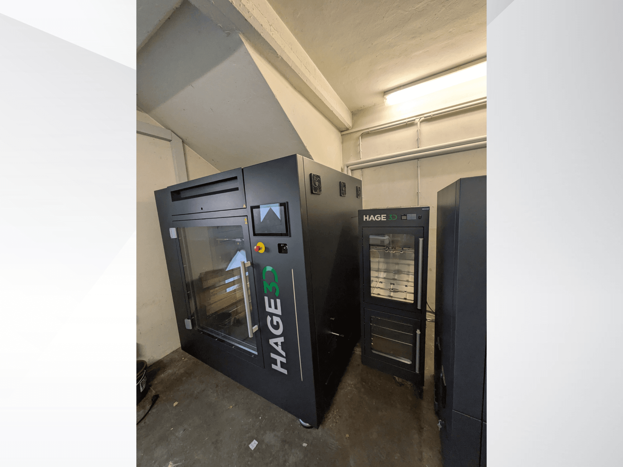 HAGE 3D Precision One plastic 3D printer in a corner view, featuring a transparent door and control panel, with storage beside it.