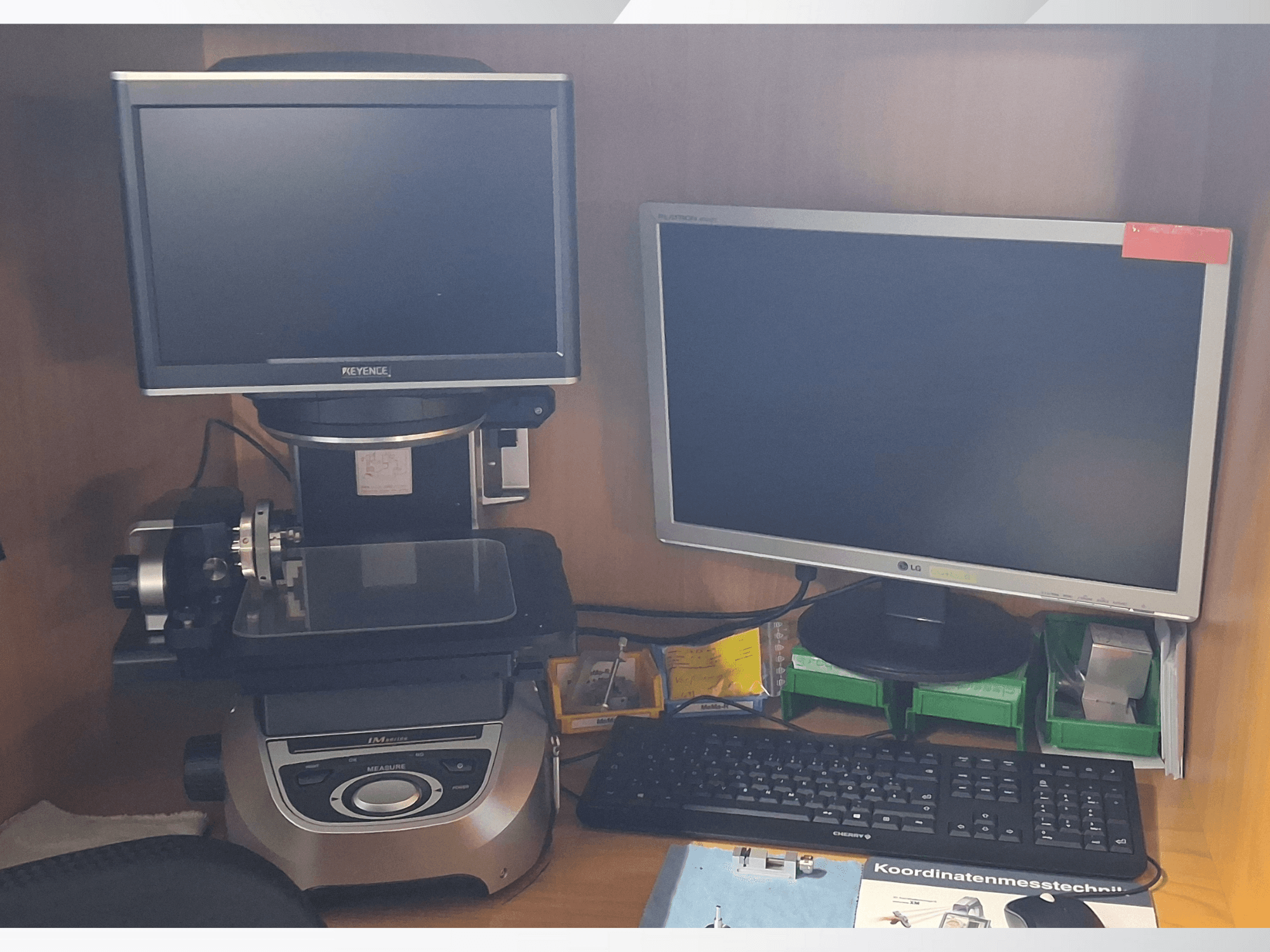 Keyence measurement system with two monitors (one LG, one Keyence) and a keyboard, viewed from the front.