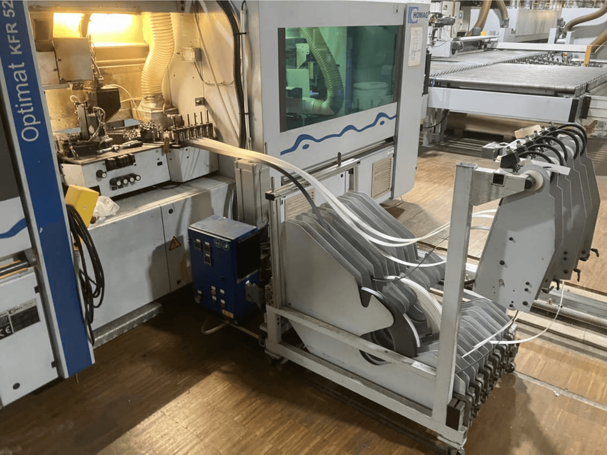 Double-sided edgebander HOMAG Optimat KFR 526/10/A3/35, viewed from the side, showcasing control panel and edge banding rollers.