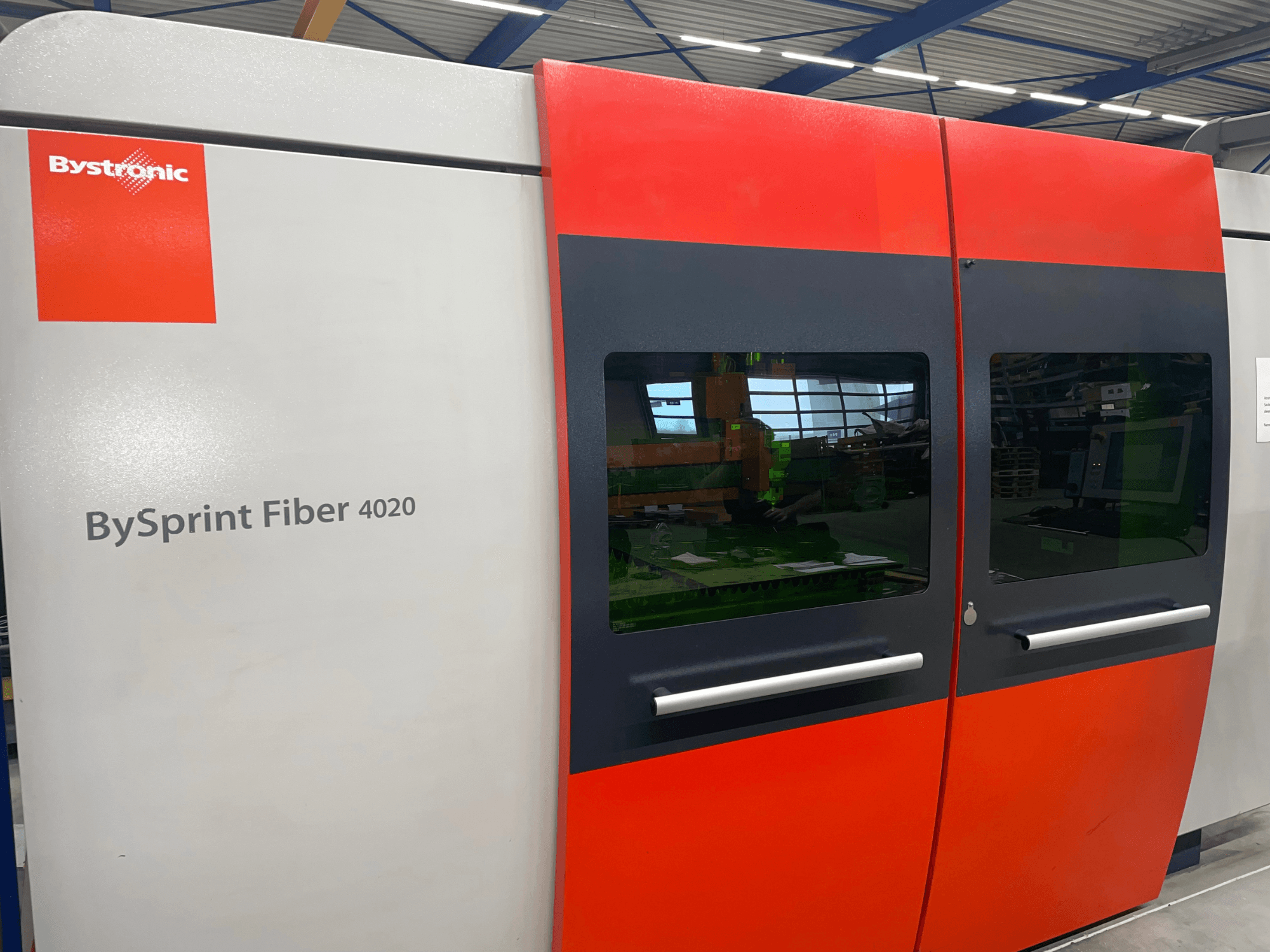 Bystronic BySprint Fiber 4020 in front view, featuring a gray and red panel design with large windows and control interface visible inside.