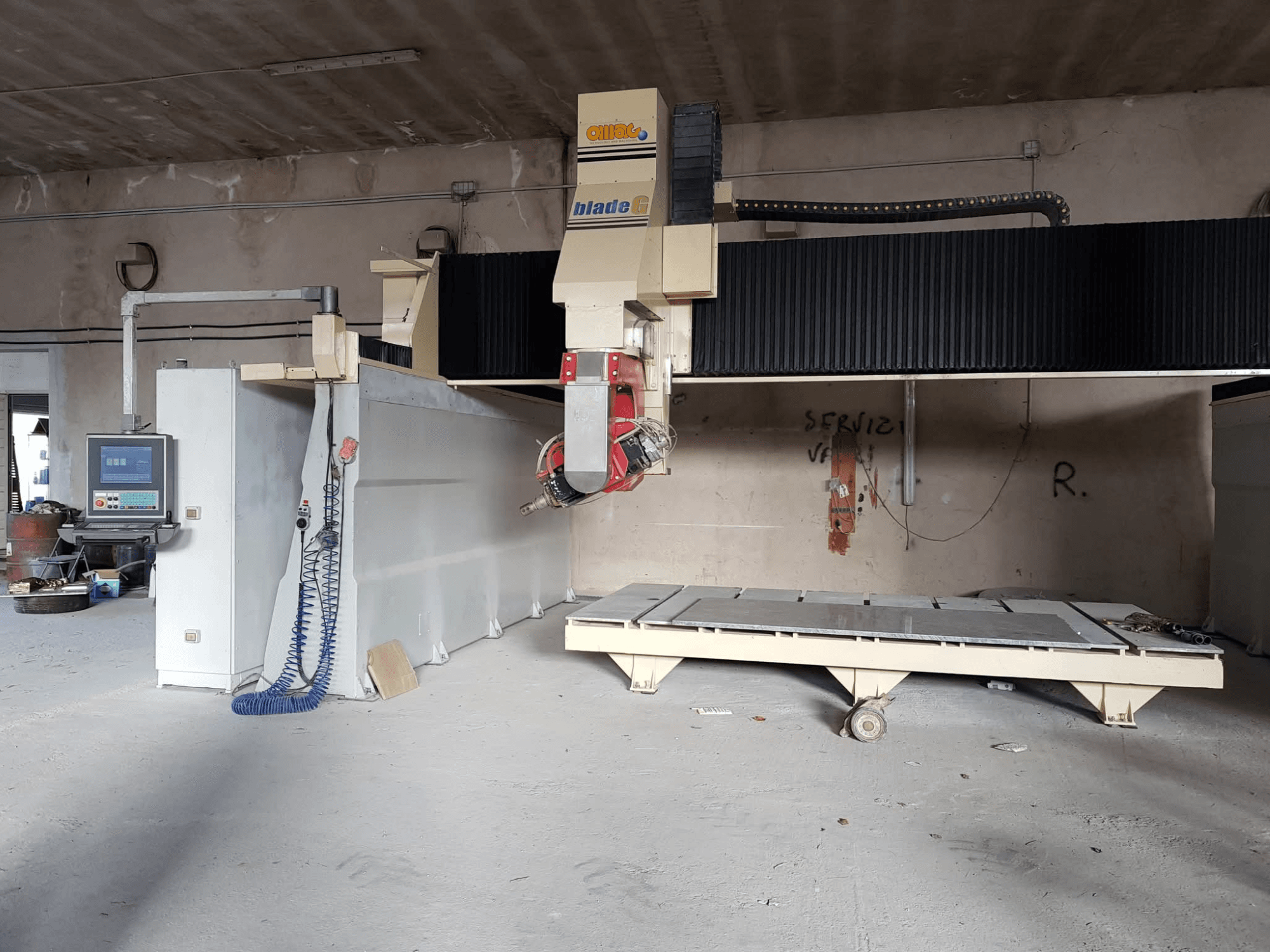 Gantry milling machine OMAG Blade G in a workshop, front view with control panel and large milling bed visible.