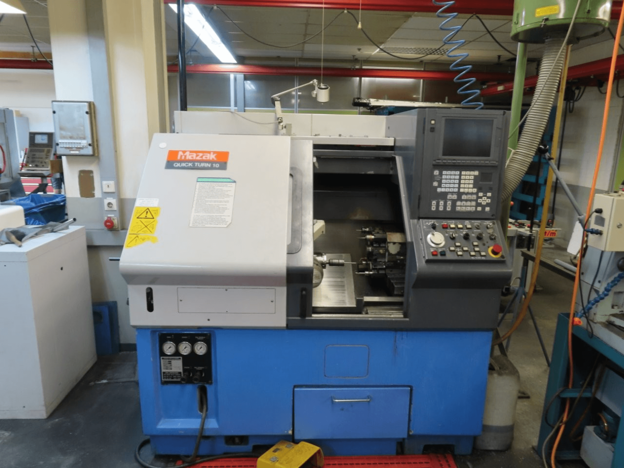 Mazak Quick Turn 10 horizontal turning machine in front view, featuring control panel, spindle, and coolant system.