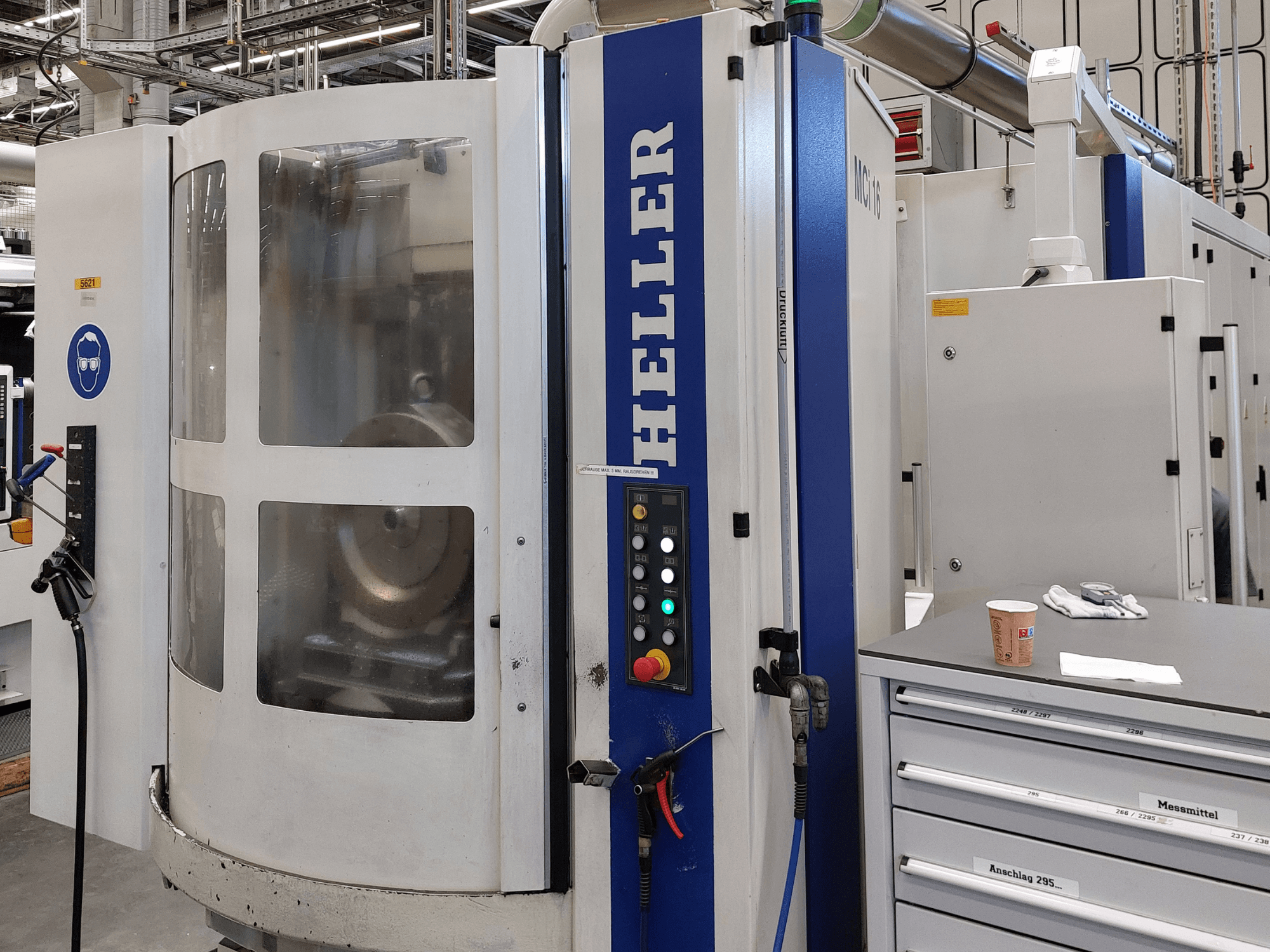Heller MCI 16 horizontal machining centre in side view, featuring control panel, transparent window, and surrounding workspace.