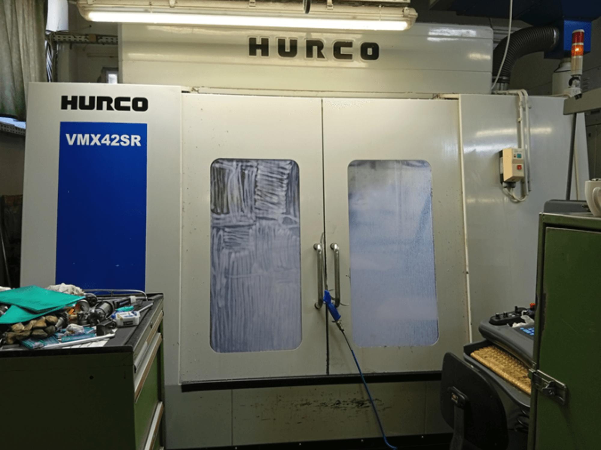 Hurco VMX 42SR vertical machining center in front view, featuring blue panel, control interface, and clean workspace.