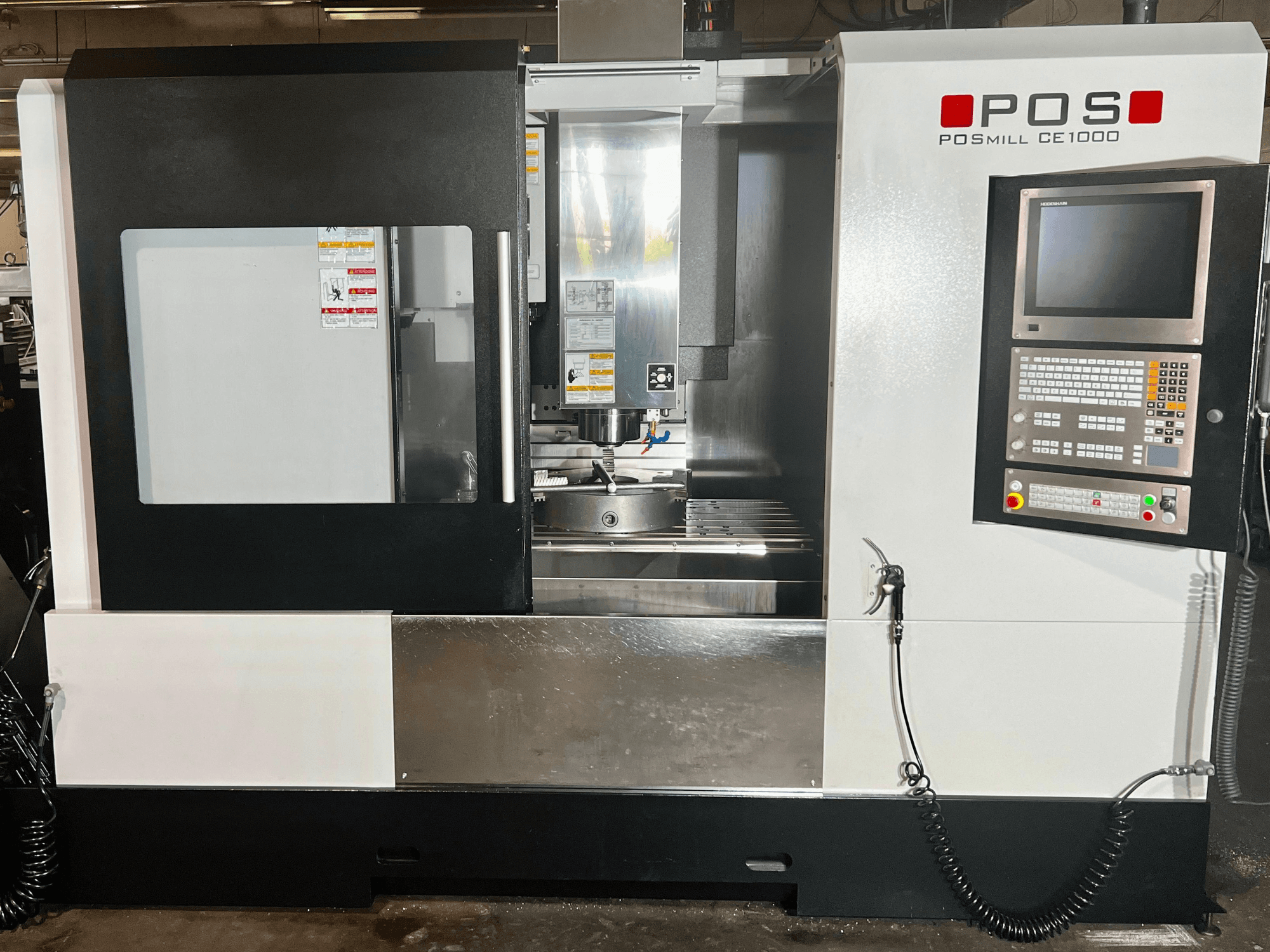 Front view of POSmill CE1000 vertical machining center, showcasing control panel, window, and metal surfaces.