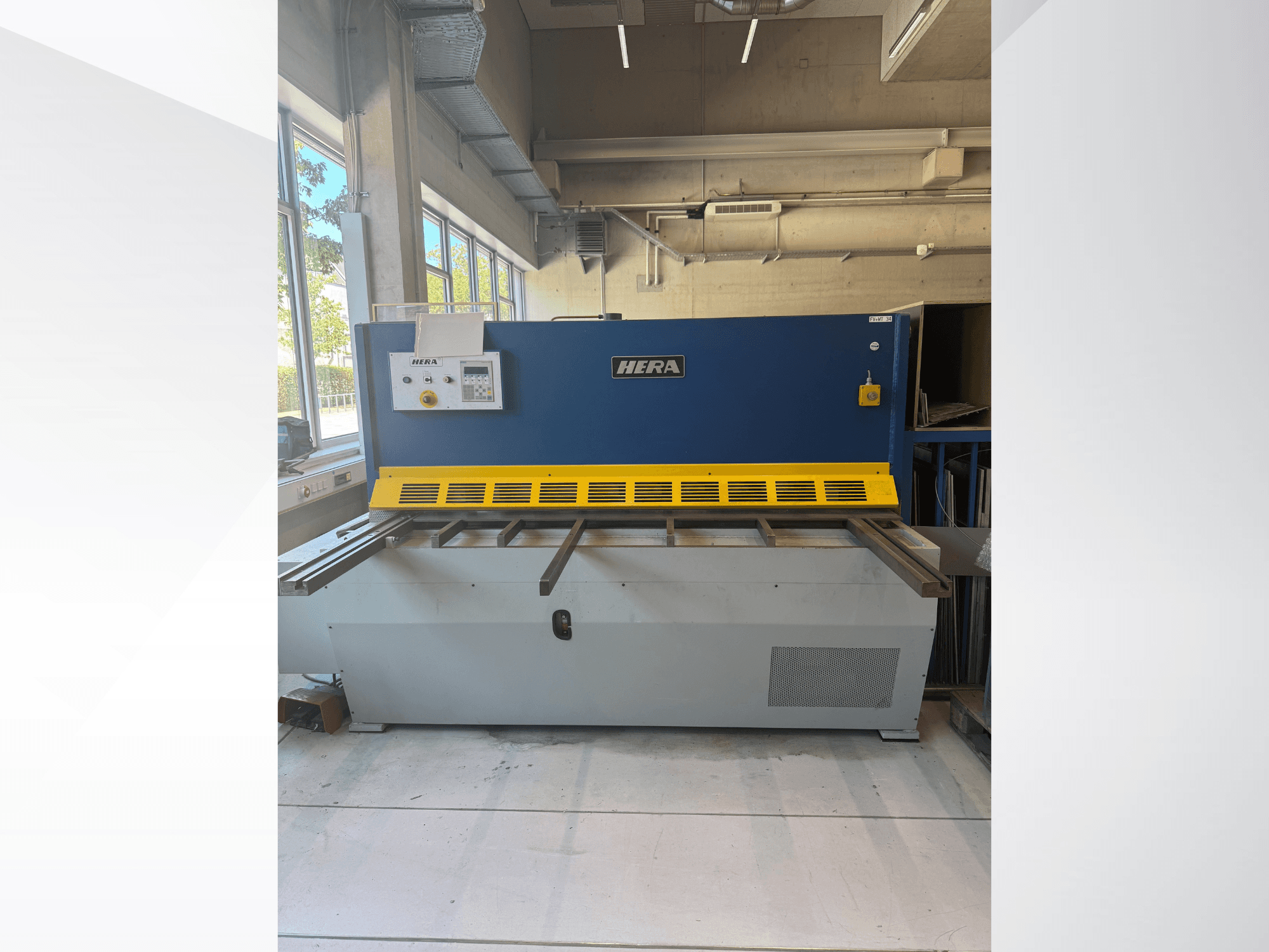 HERA TS 2000x6 hydraulic shearing machine in front view, featuring a blue and yellow design with control panel and cutting bed.