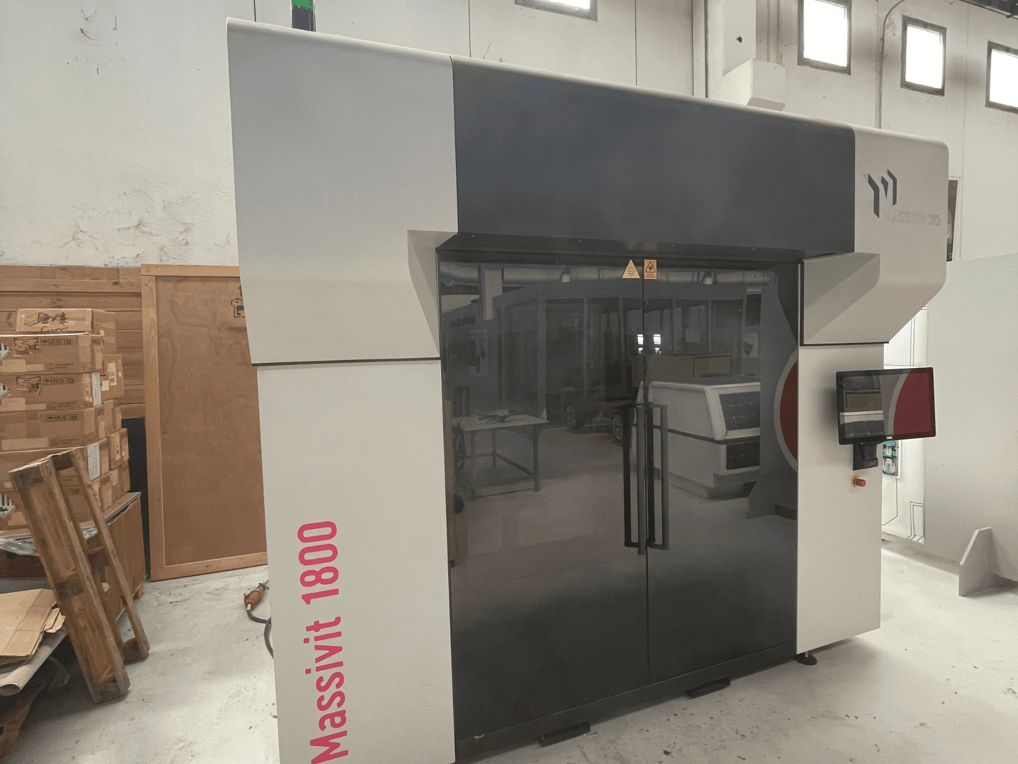 MASSIVIT Massivit 1800 plastic 3D printer shown in side view, featuring a touchscreen and sleek black and white design.