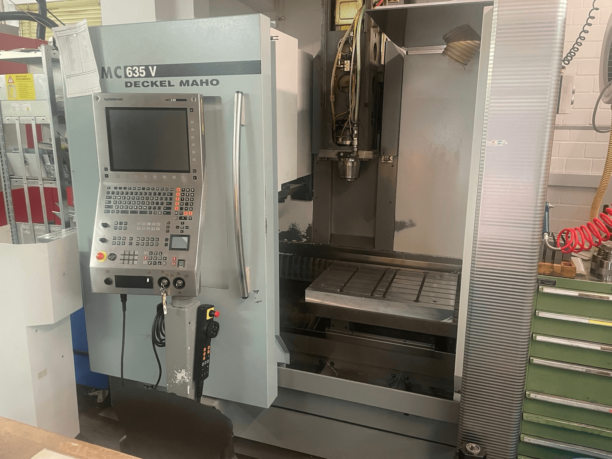 Front view of DECKEL MAHO DMC 635 V vertical machining center with control panel and open work area, showing tool head and bed.