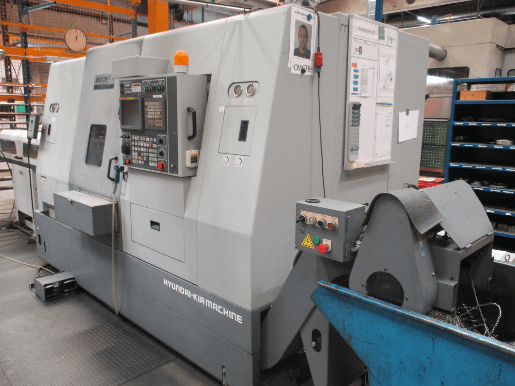 Front view of HYUNDAI KIA SKT250SY horizontal turning machine; features control panel, chip bin, and safety signage.