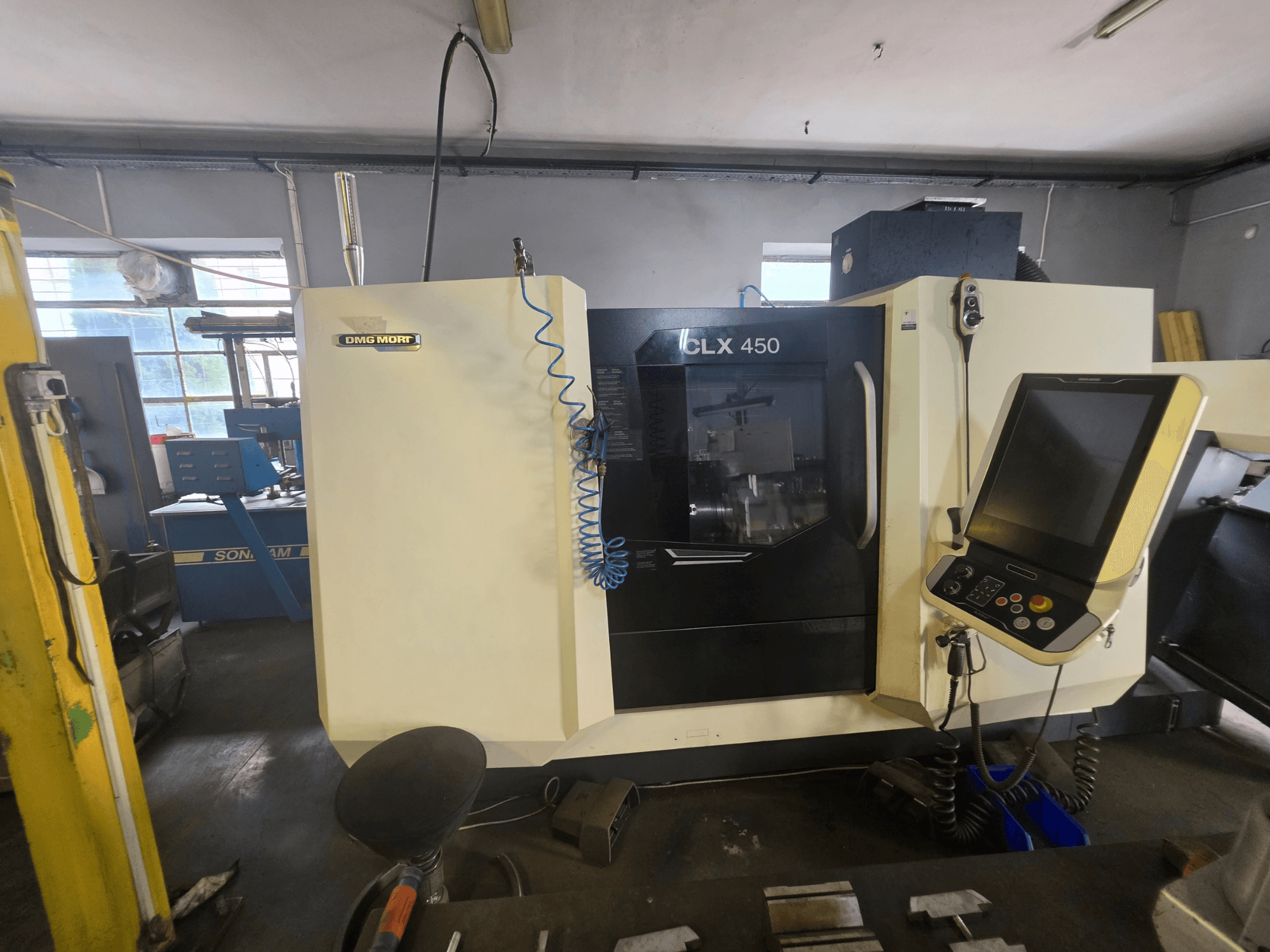 DMG MORI CLX 450 V6 horizontal turning machine in front view, featuring a control panel and visible branding.