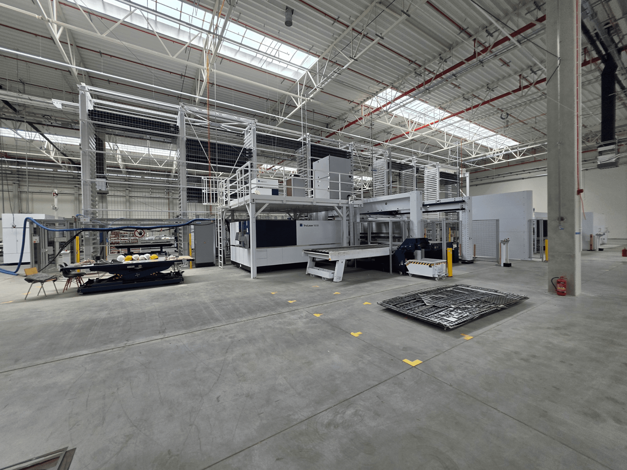 TRUMPF Automated Sheet Metal Production System, side view showing machinery, workspace, and tools in a large industrial setting.
