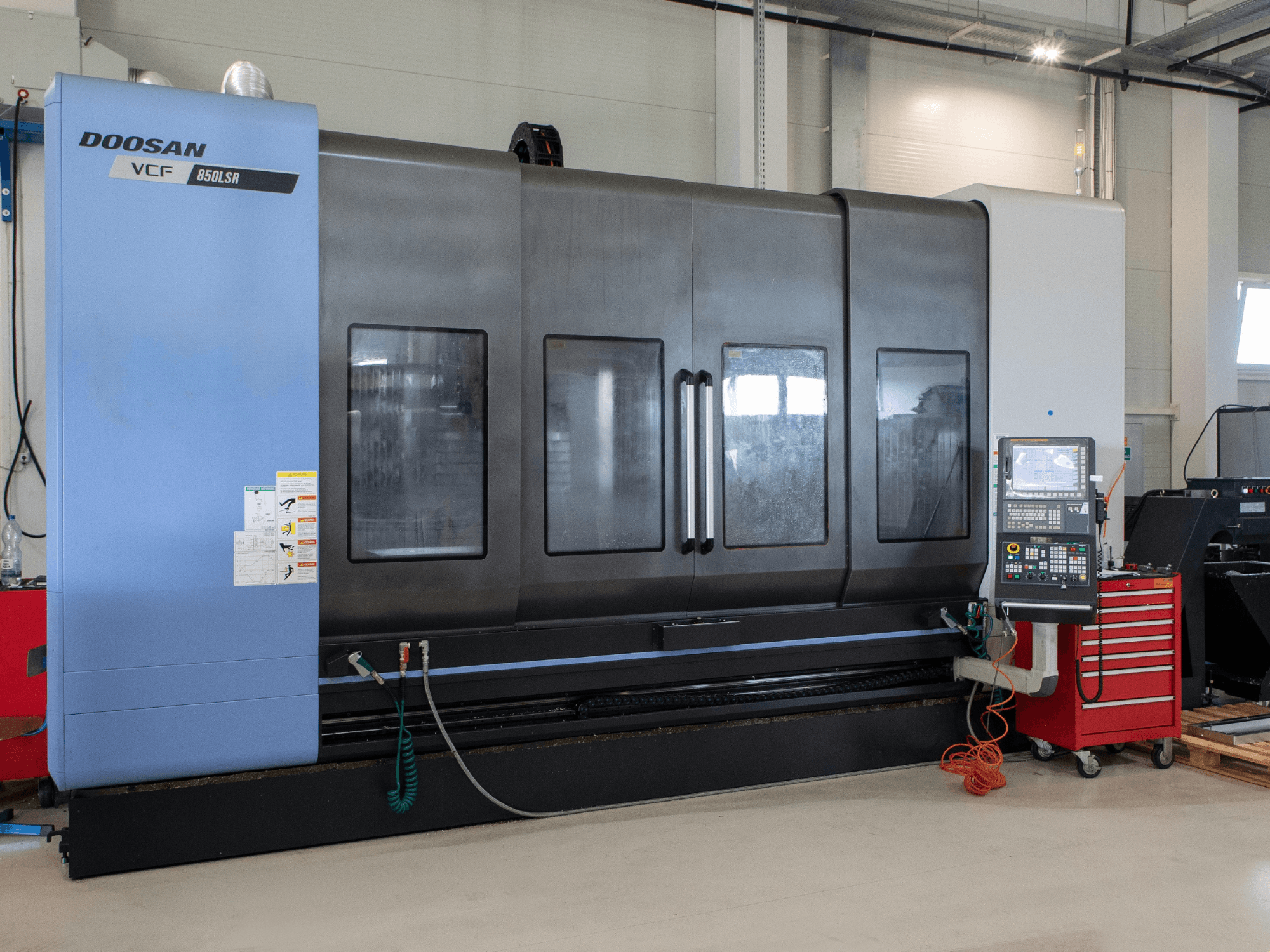 DOOSAN VCF850 Mill-Turn Centre, front view; features large dual windows, control panel, and tool storage. Ideal for machining.
