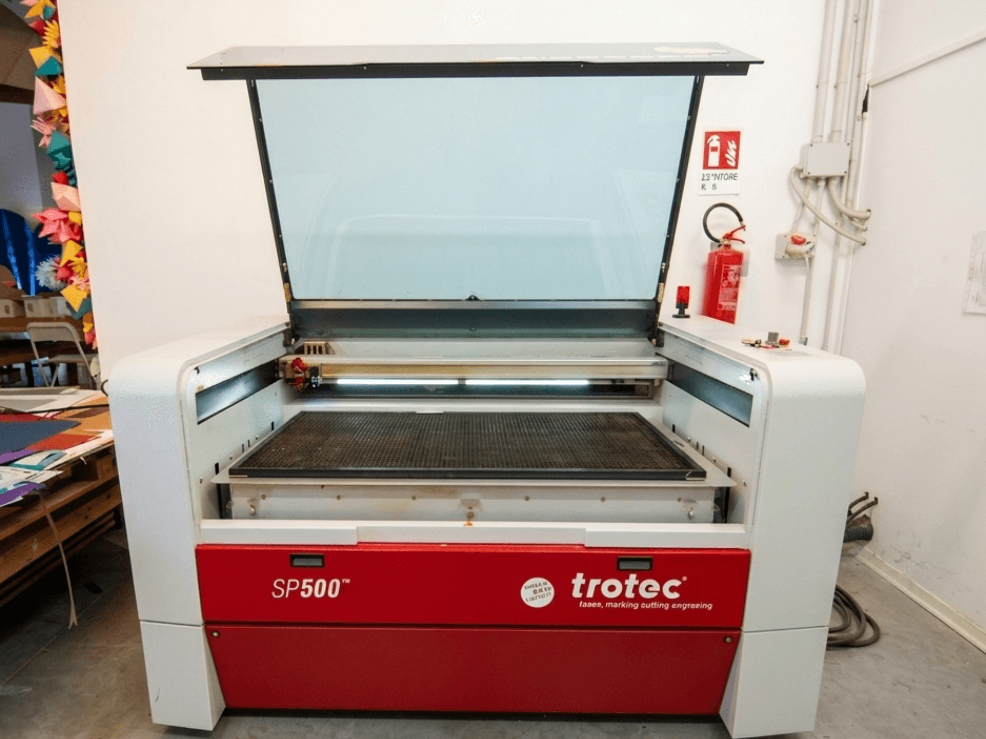 Trotec SP500 C200 laser engraving machine in front view, with an open lid showing the work area and controls.