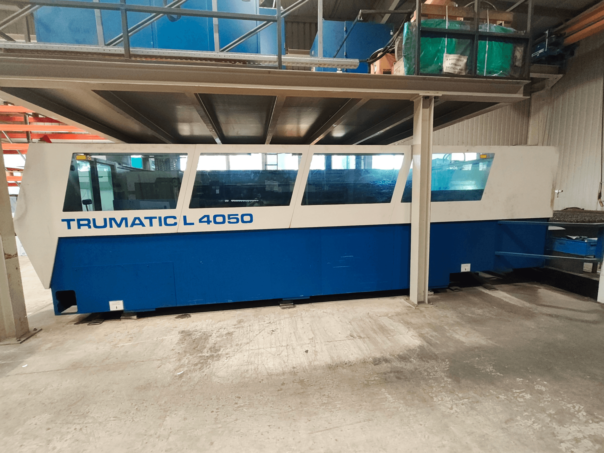 CO2 laser cutting machine TRUMPF TruLaser 450 in a side view, featuring a blue and white design, with visible control panel and workspace.
