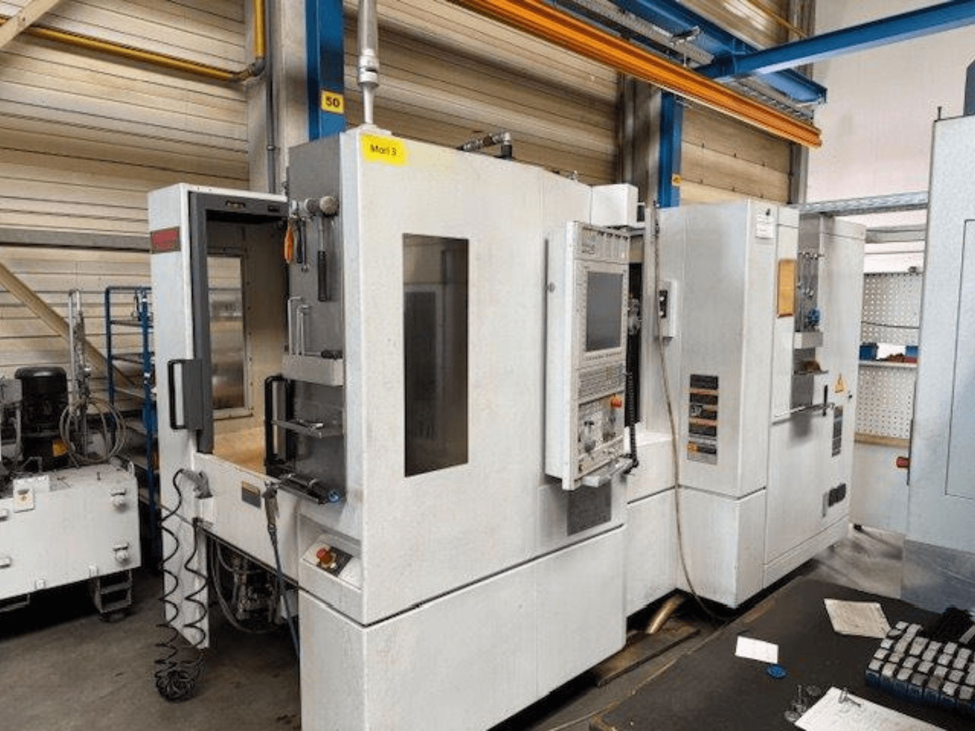 Front view of a MORI SEIKI NH4000 DCG horizontal machining center with open door and control panel visible, showing operational space.