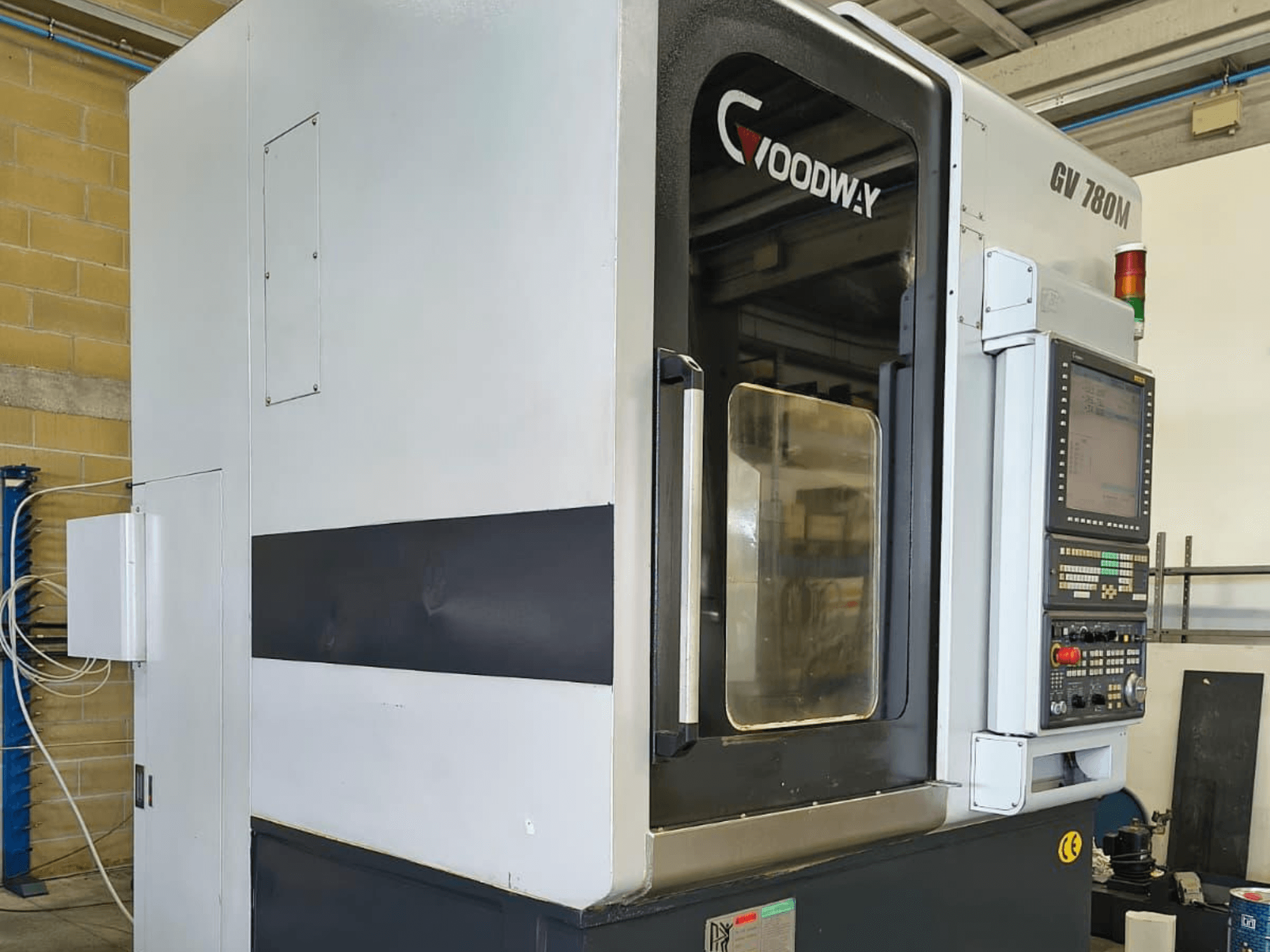 Goodway GV 780 M vertical turning machine, side view, showcasing control panel, safety features, and clean exterior design.