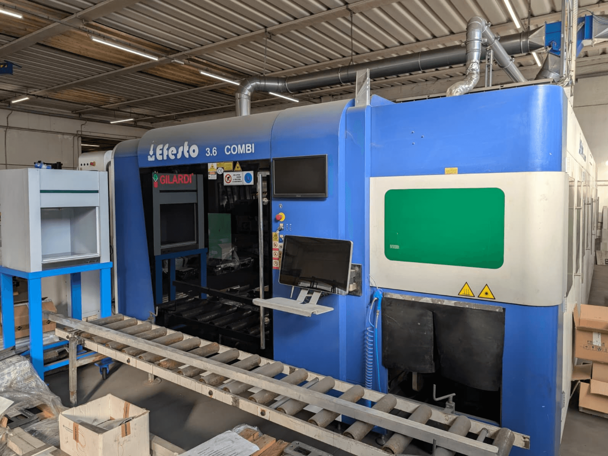 Fiber laser cutting machine EFESTO 3.6 COMBI, side view, featuring control panel and safety indicators with a blue exterior.