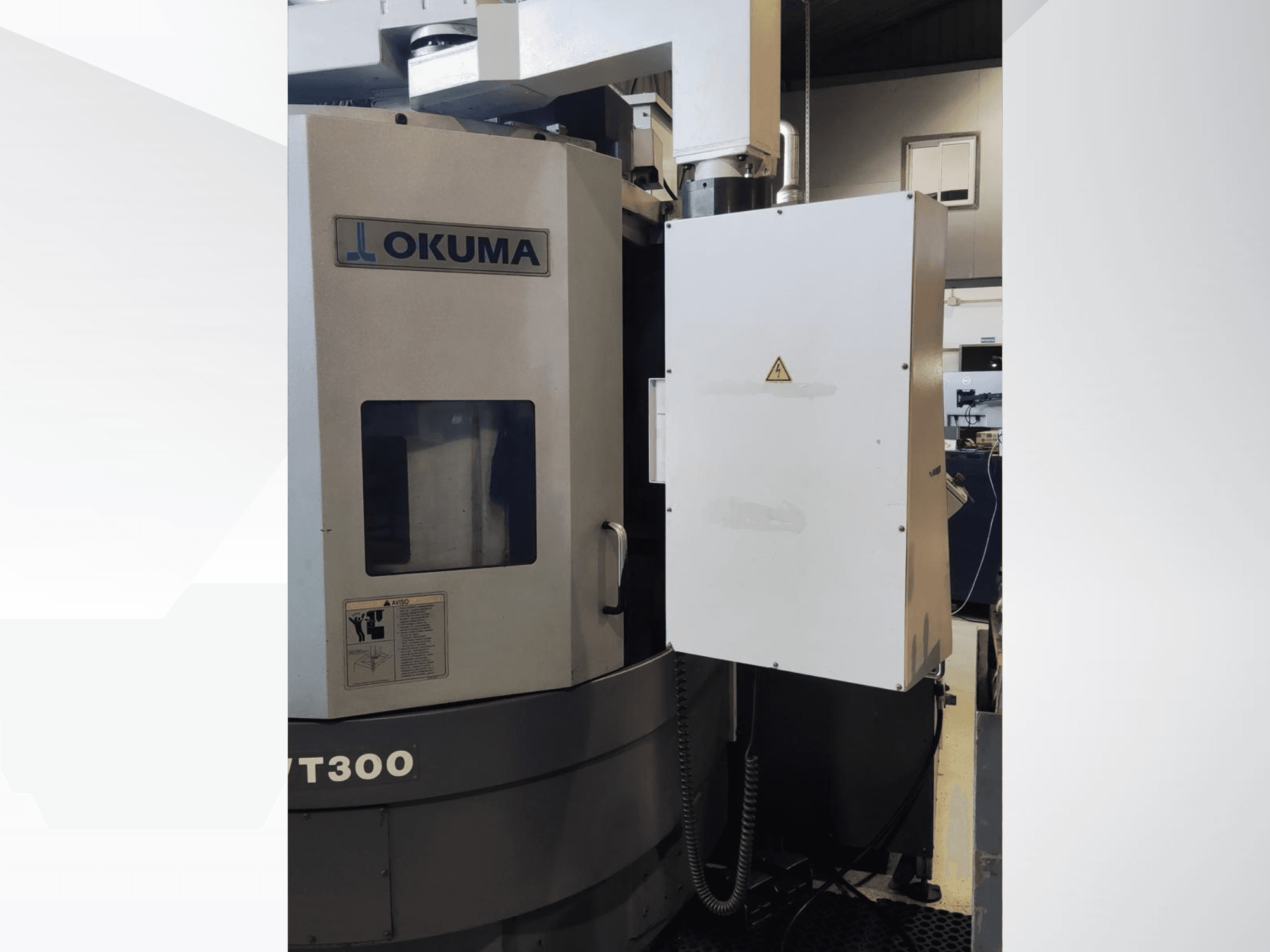 Okuma LVT300 vertical turning machine, front view, showcasing control panel and labeled safety features.