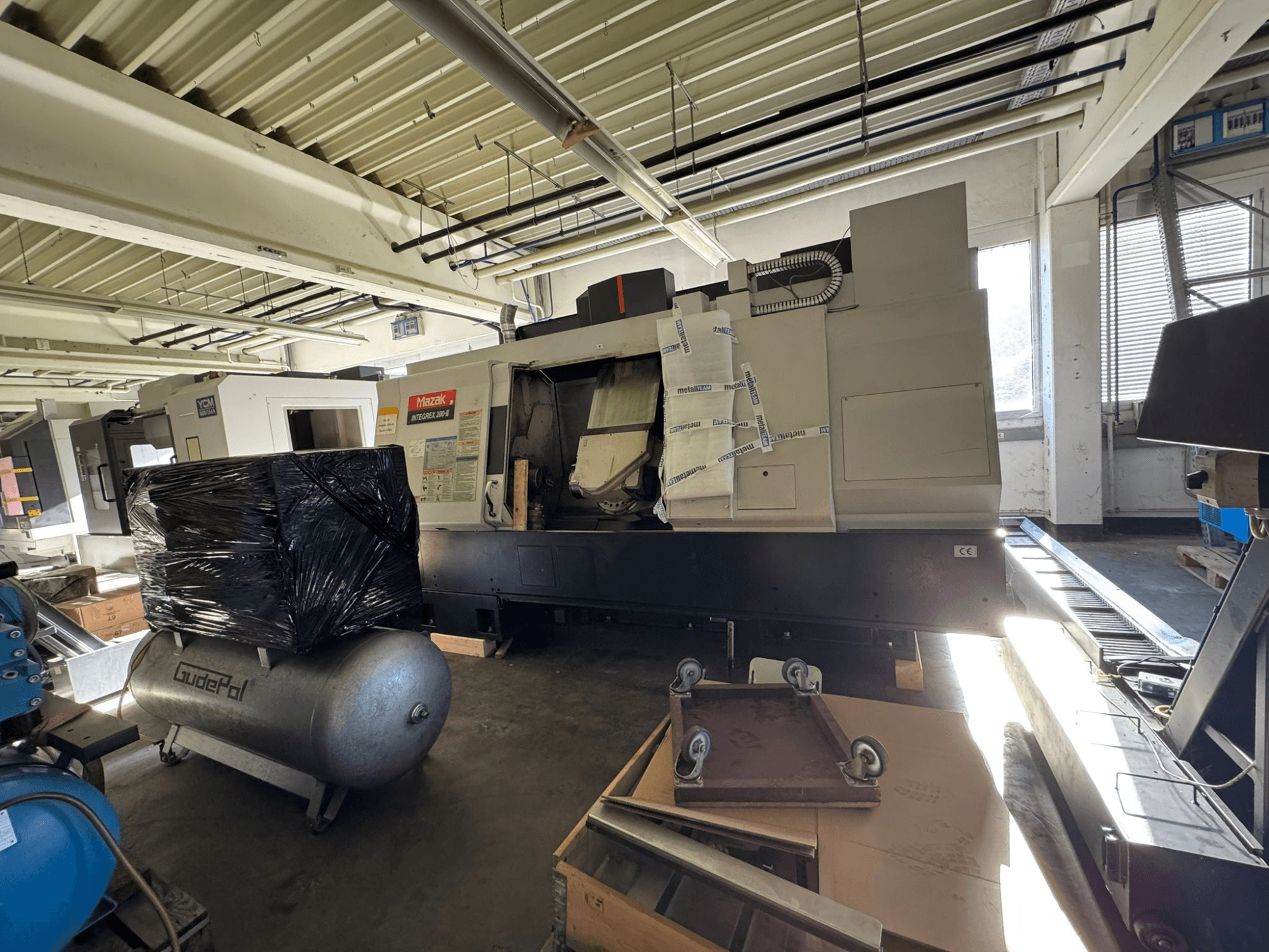 Front view of Mazak INTEGREX 200-3 Mill-Turn Centre in a workshop, partially obscured by packaging and nearby equipment.