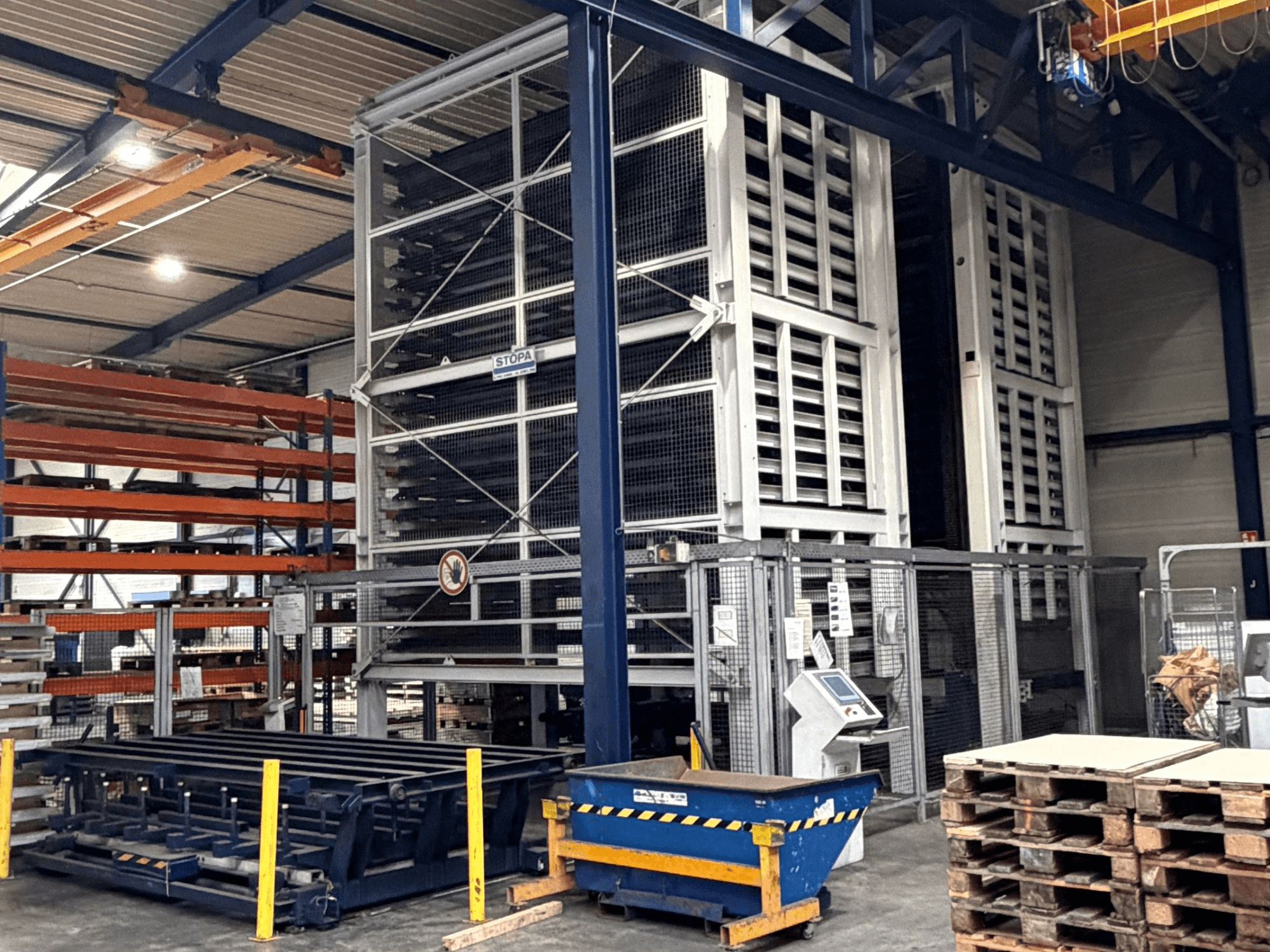 TRUMPF STOPA 4000x2000 automation system in a warehouse, side view showing racks and control panel within storage area.