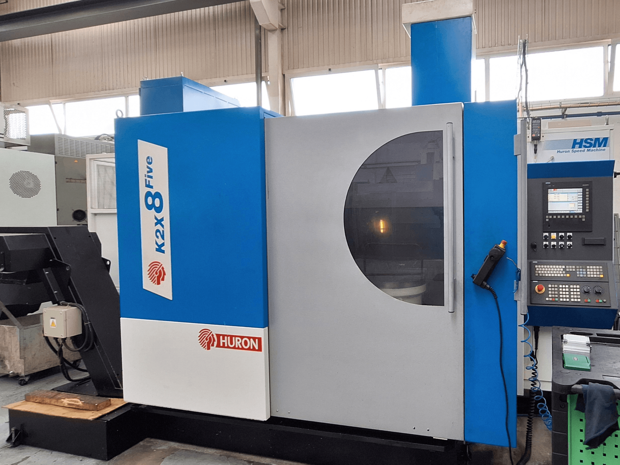 Gantry milling machine Huron K2X 8 Five, front view showing control panel and large viewing window.