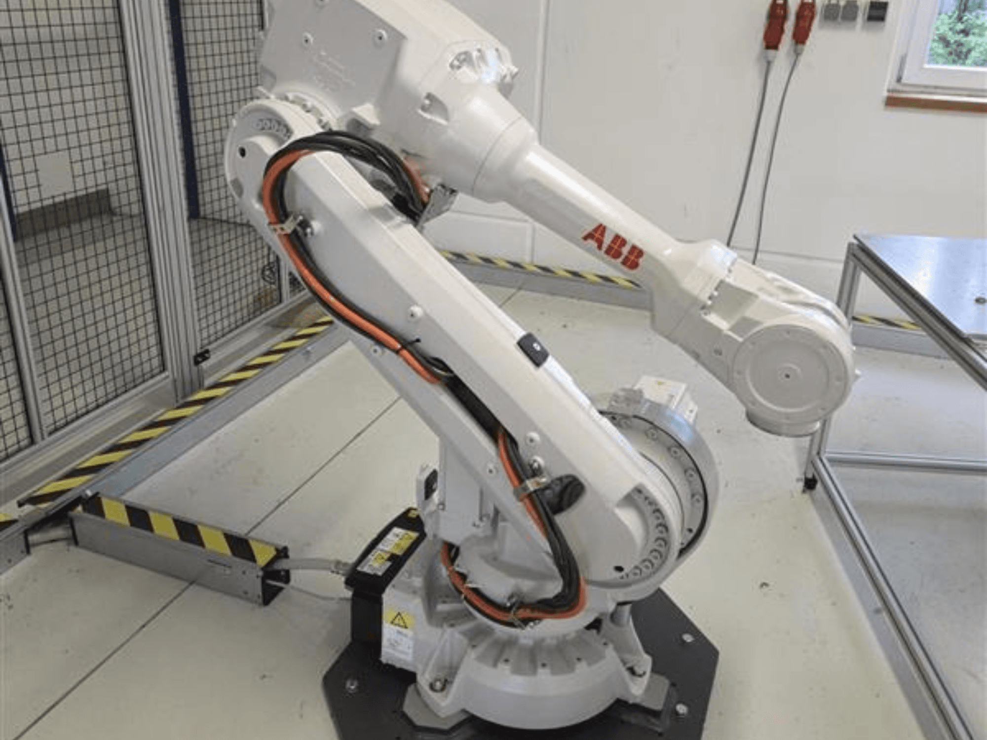 ABB IRB 4600-45/2.05 robot arm in profile view, showcasing its articulated design and cables connected to the base.