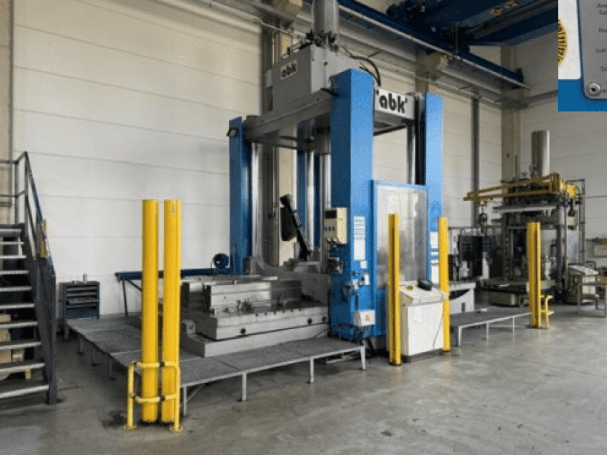 ABK abk-TP-20-250 machine tool from front view, featuring safety yellow barriers and surrounding machining equipment.