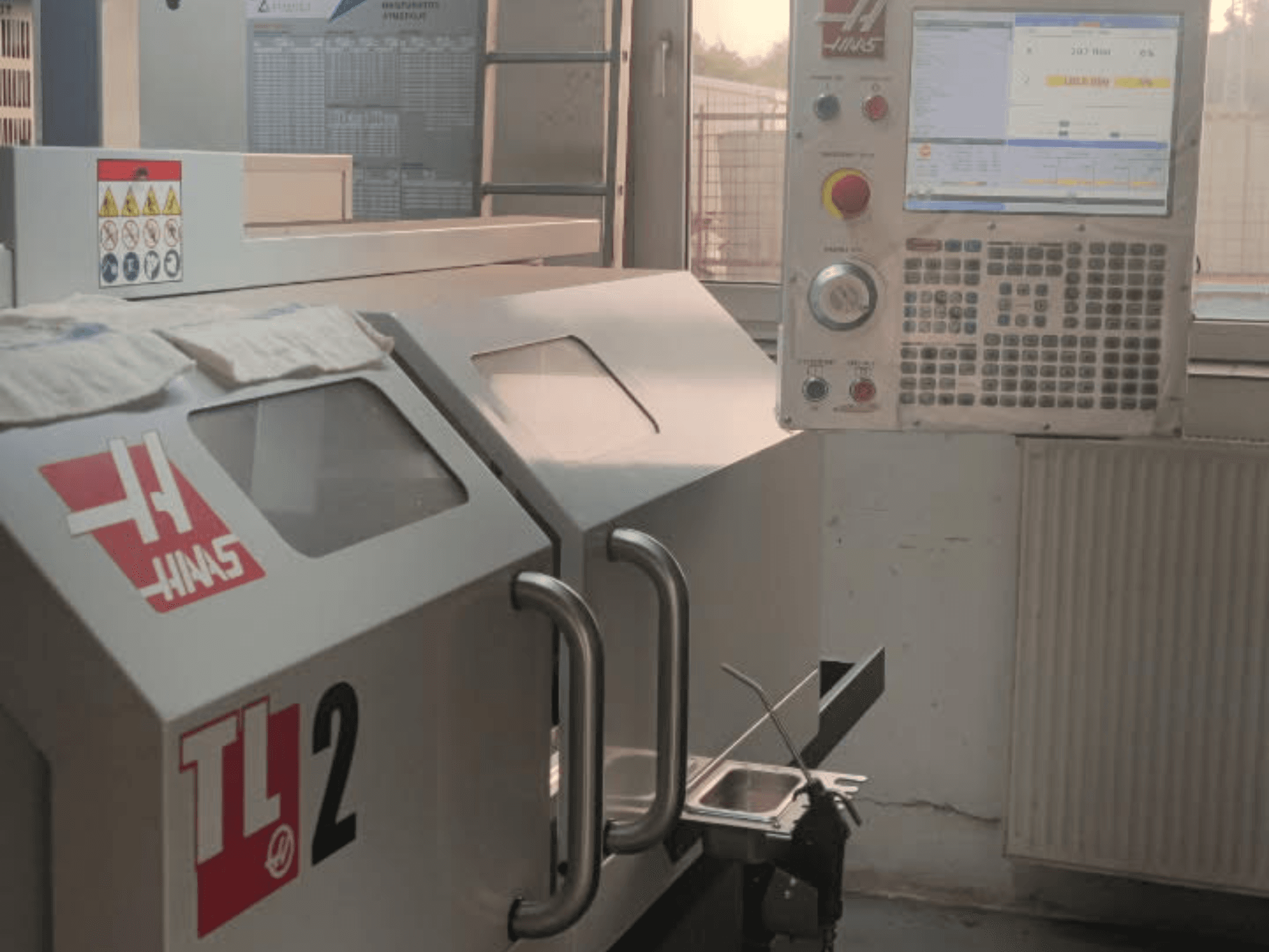 Haas TL-2 horizontal turning machine front view, featuring control panel, metal casing, and safety signage.