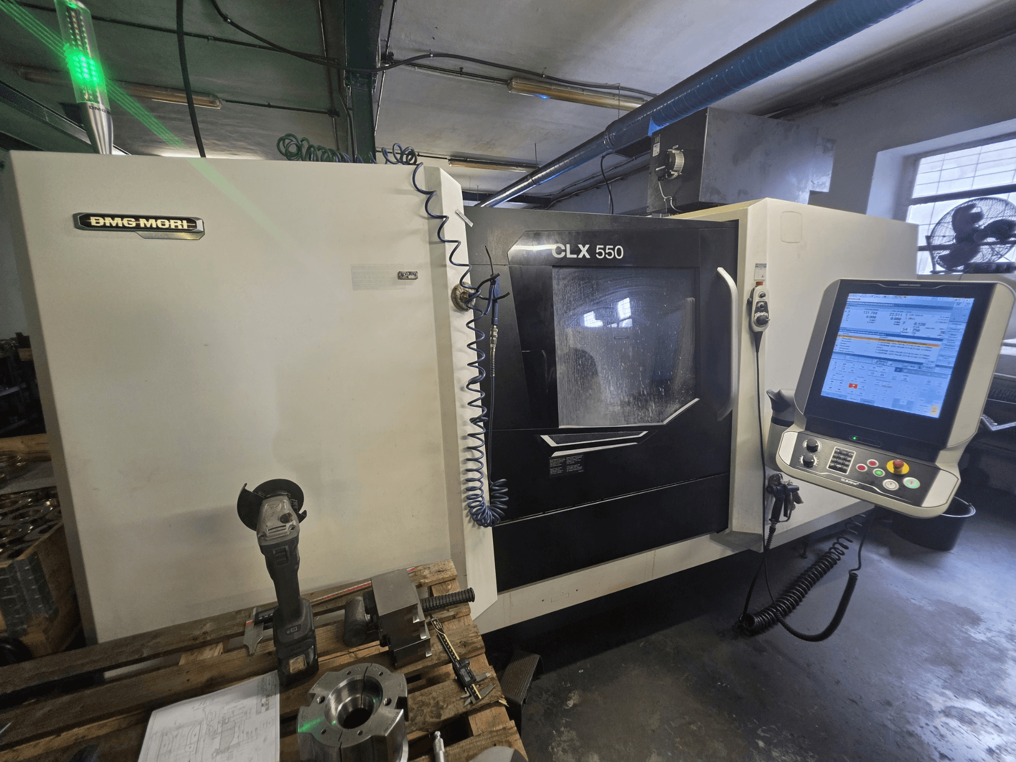 DMG MORI CLX 550 V3 horizontal turning machine, front view showing control panel, cutting tools, and machine housing.