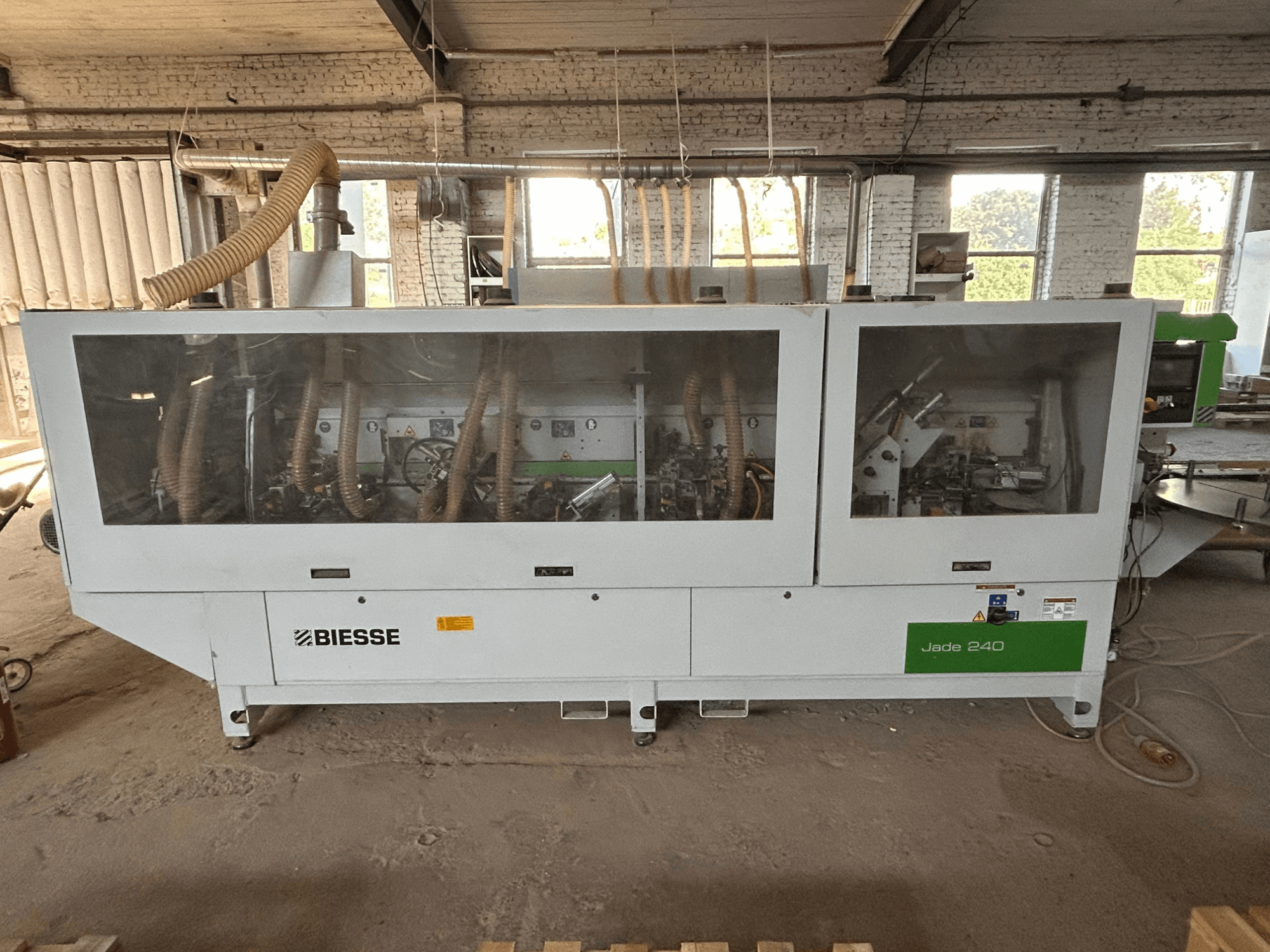BIESSE Jade 240 edgebander in white and green, front view showing control panel and detailed machinery inside.