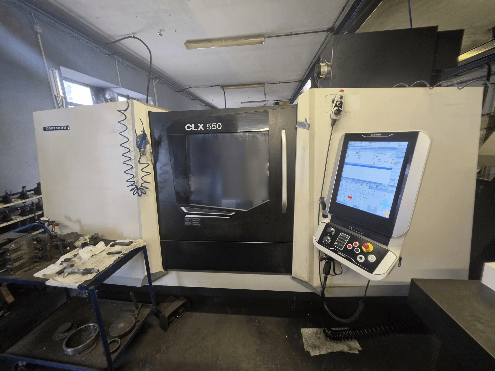 DMG MORI CLX 550 V3 horizontal turning machine, front view, showcasing control panel and workspace with tools.