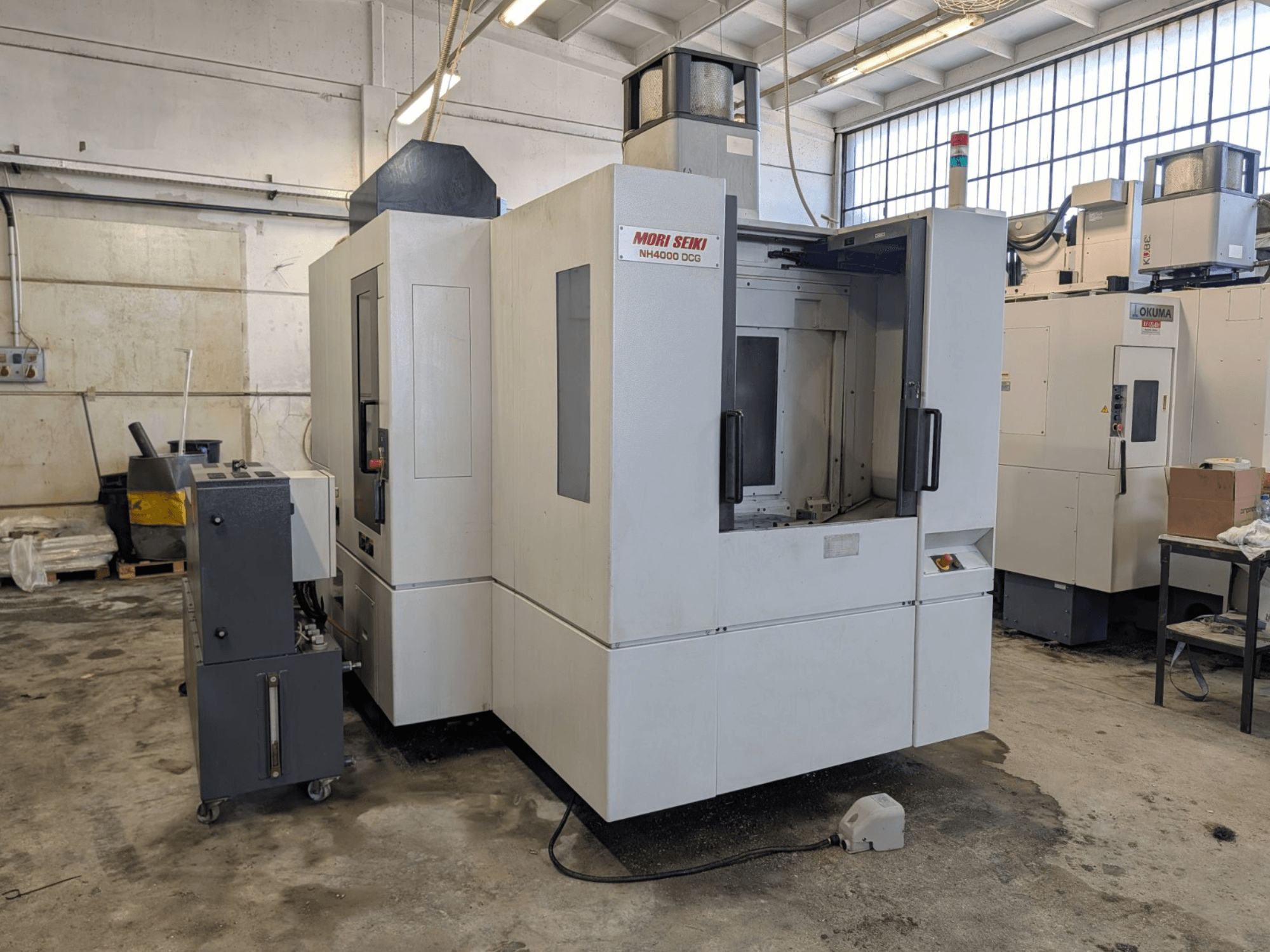 MORI SEIKI NH 4000 DCG horizontal machining center, front view, showcasing control panel and work area, gray and white finish.