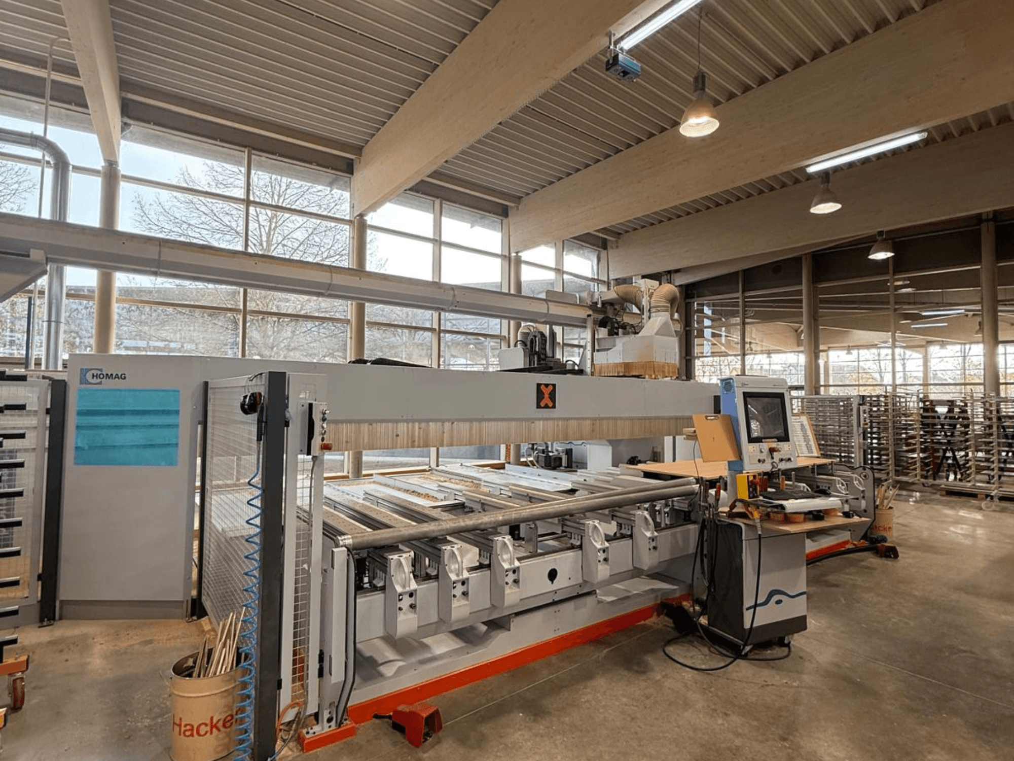 HOMAG CNC machine in a workshop, front view, showcasing a control panel and multiple tool slots for precision woodworking.