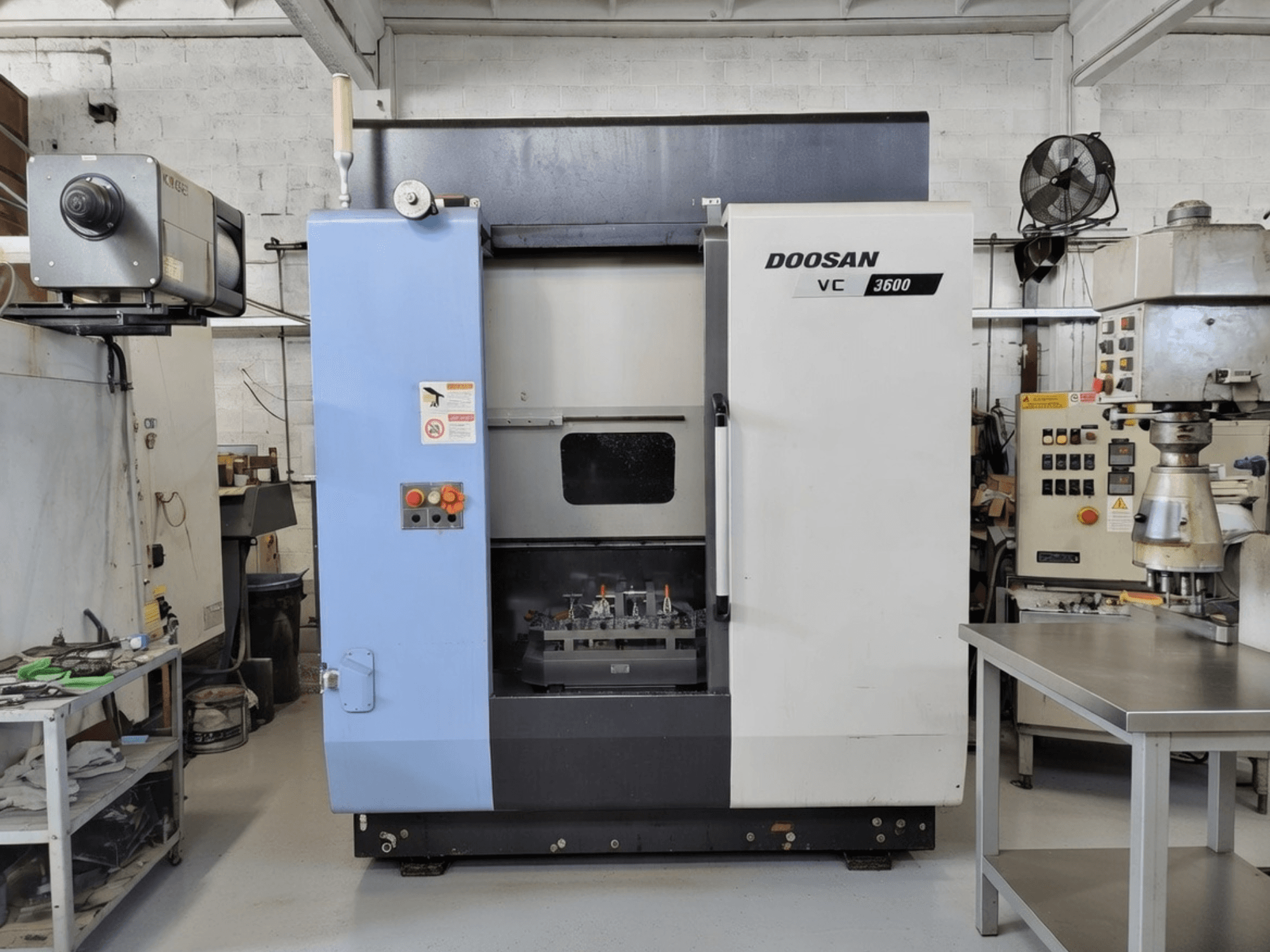 DOOSAN VC 3600 vertical machining centre in front view, featuring control panel and open door revealing workspace.