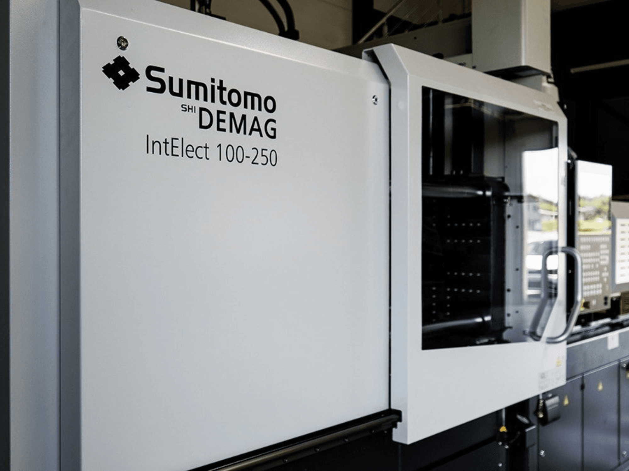 Front view of SUMITOMO SHI DEMAG IntElect 100/250 electrical injection moulding machine with control panel and safety features.