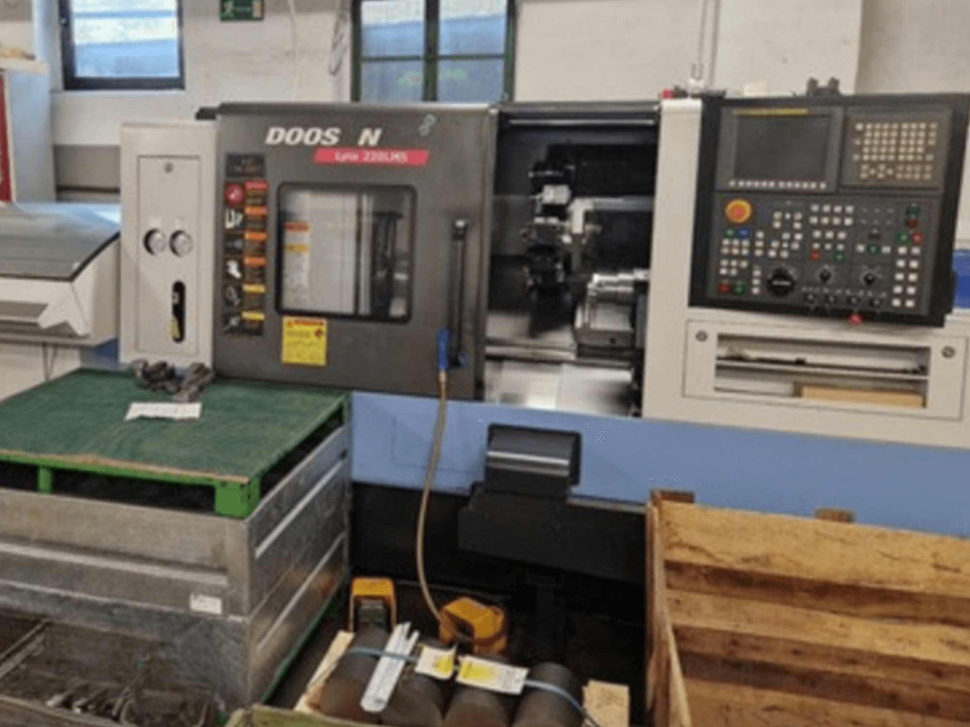 DOOSAN Lyax 220 LMS horizontal turning machine in front view, showcasing control panel, tools, and workspace.