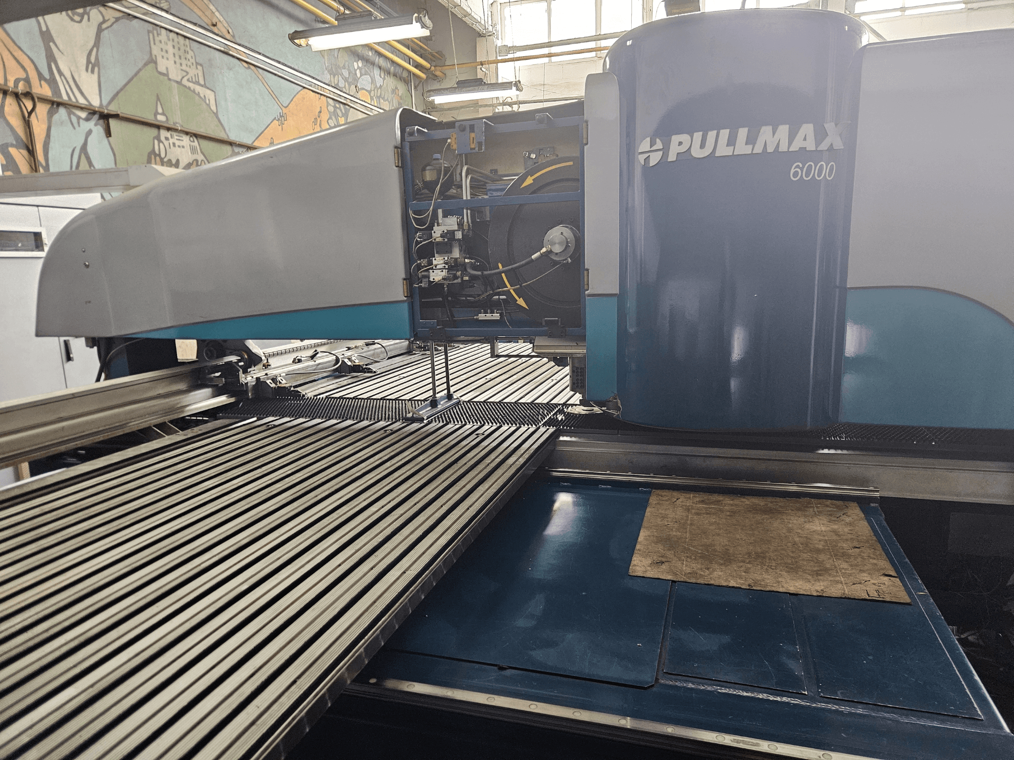 Front view of a Pullmax 6000 CNC punching machine, featuring a sleek design, operational panel, and metal work surface.