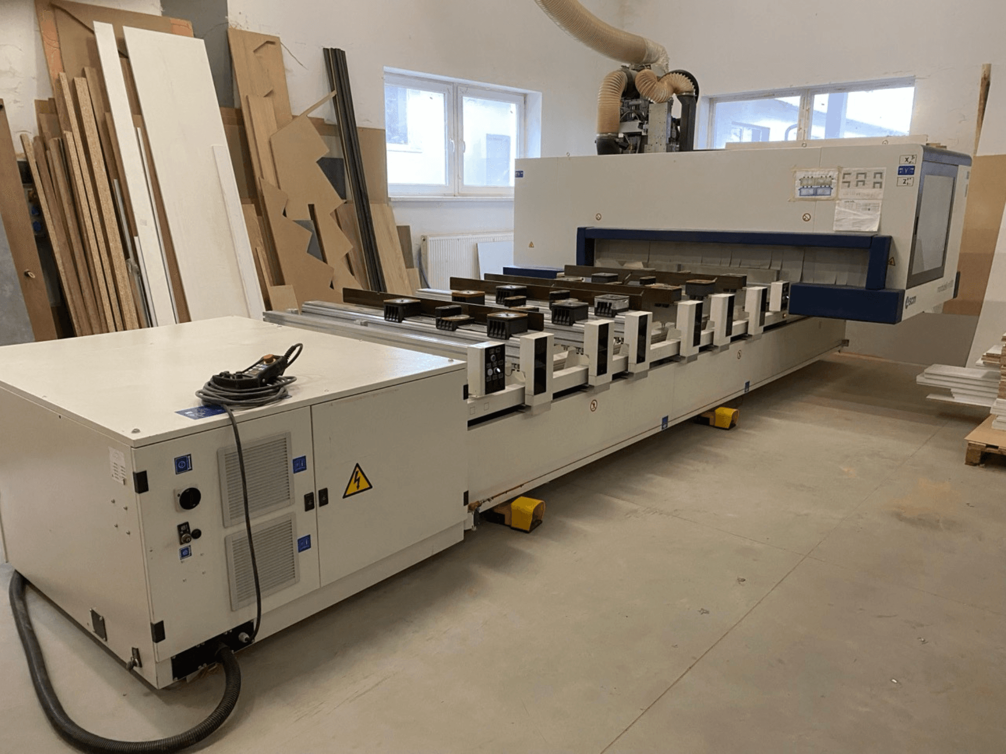 SCM Morbidelli Author M100 CNC wood machining center in a workshop, showcasing front view with control panel and dust extraction.