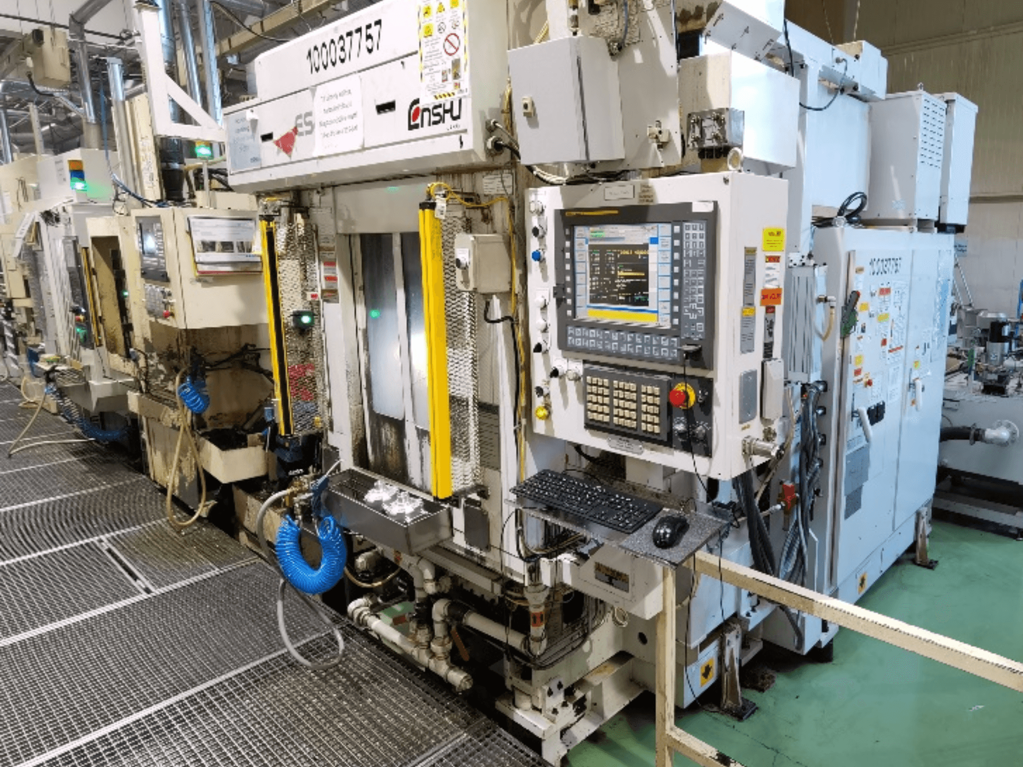 Alt text: Front view of Enshu ES400 vertical machining center, featuring control panel, keyboard, and detailed machine components.