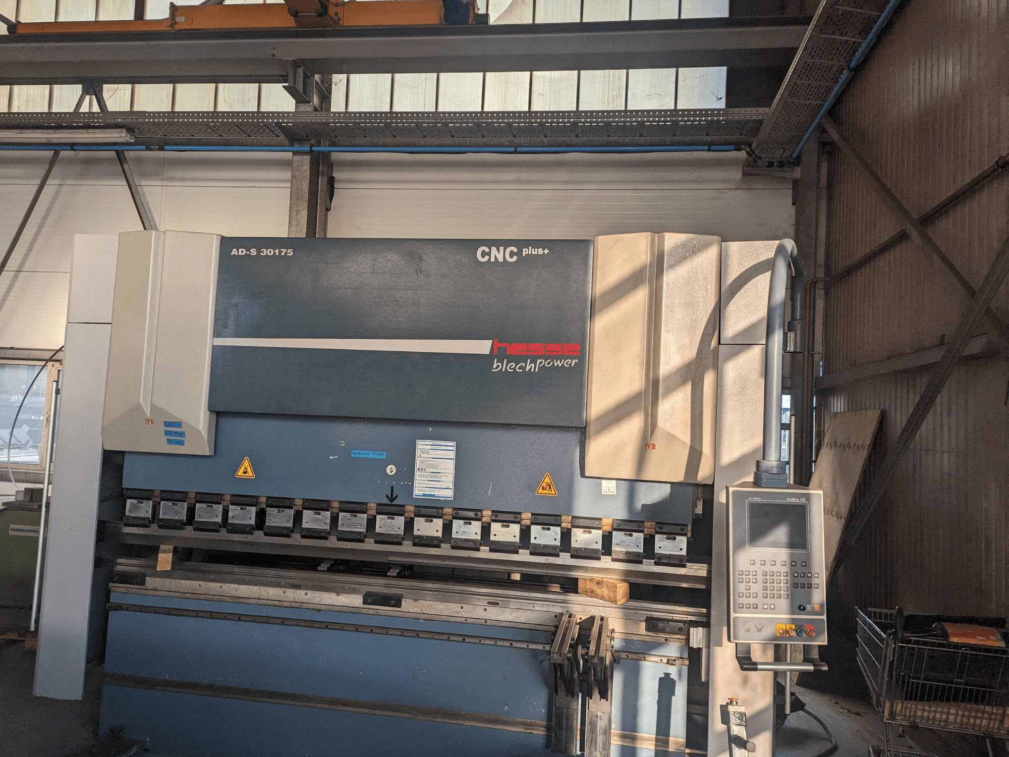 Hesse AD-S 30175 CNC bending machine, front view, featuring control panel and tools, set in a workshop environment.