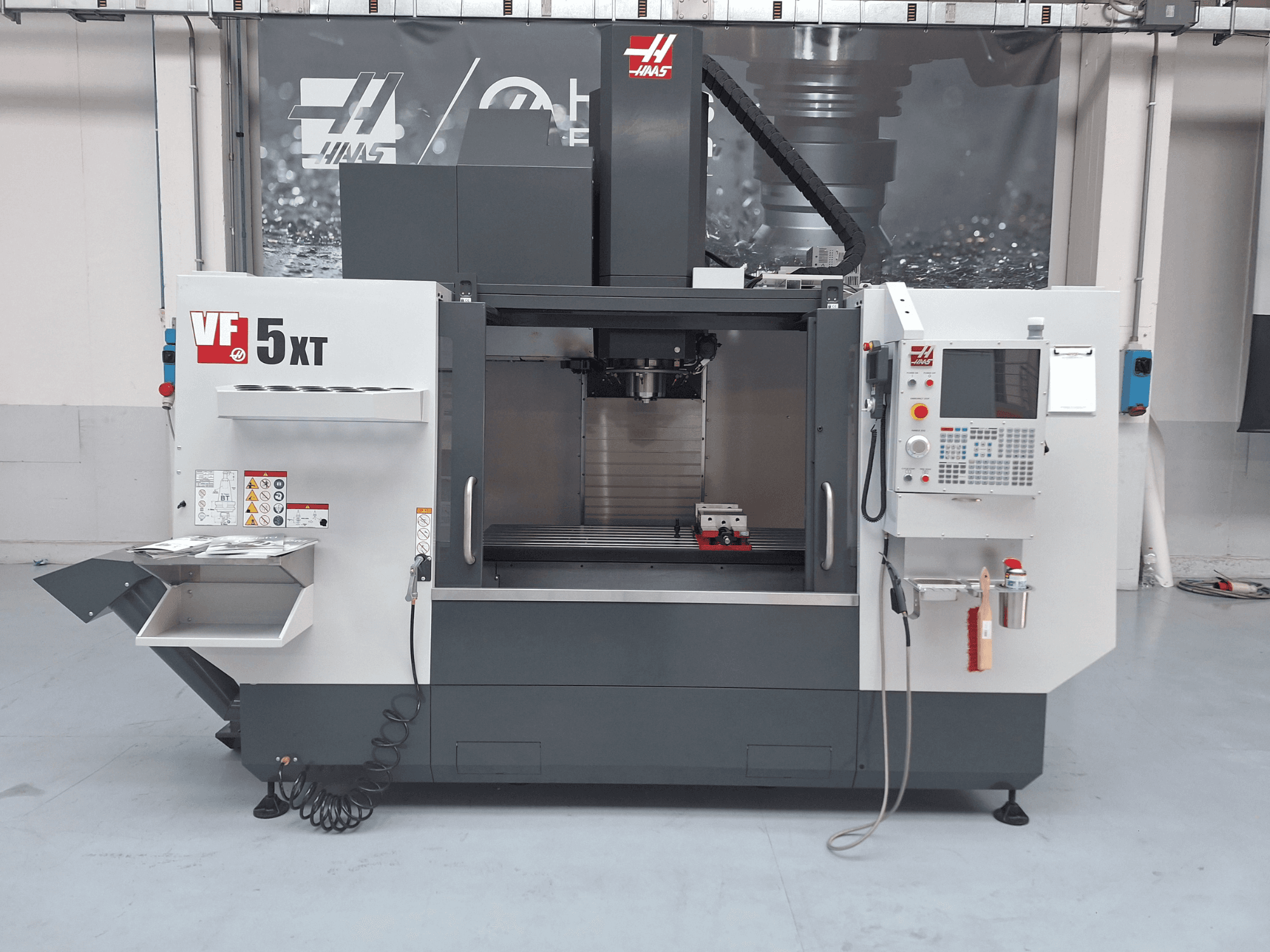 HAAS VF-5/50XT vertical machining center, front view, showcasing control panel, spindle area, and tool storage.