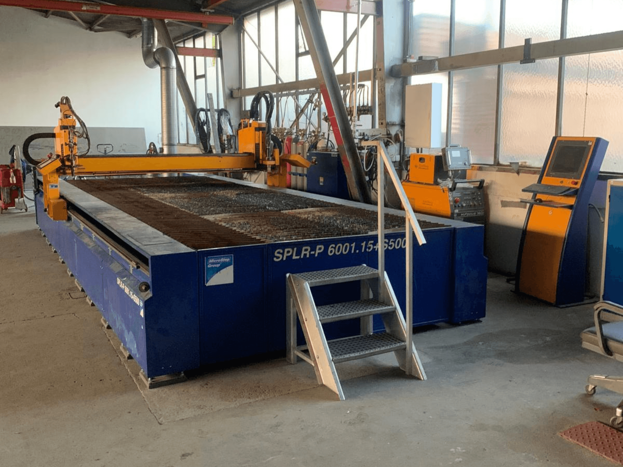 MicroStep SPLR-P plasma cutting machine in a workshop view, featuring a metal cutting table and control panel.