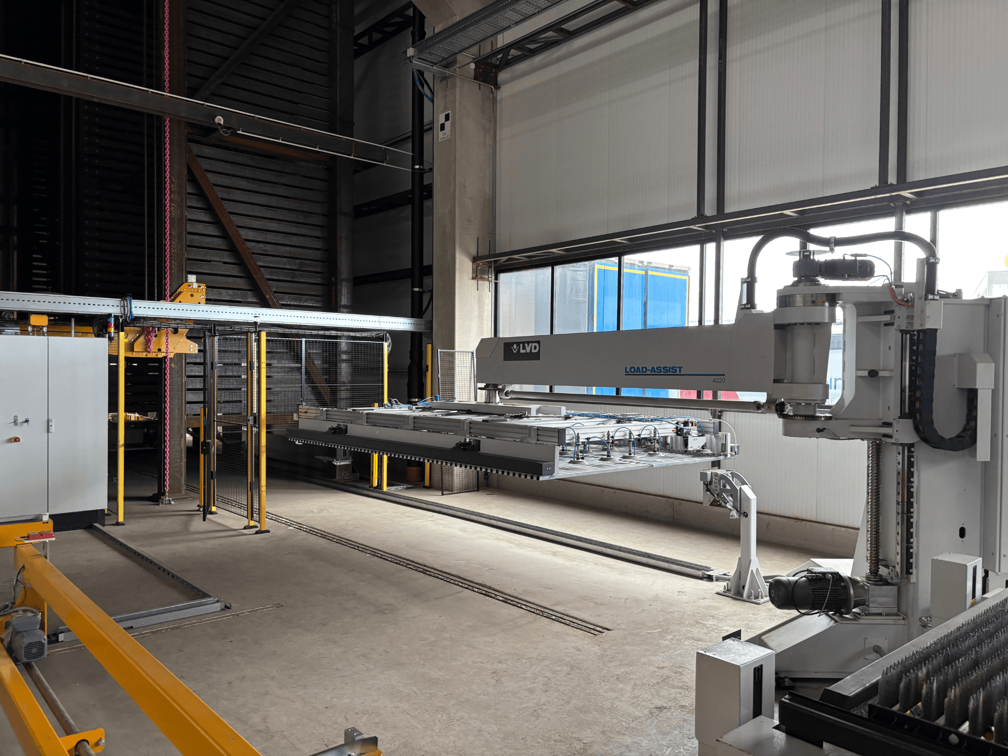 LVD Load-Assist 4020 automation equipment in a front view with a robotic arm and loading system visible in a large workspace.
