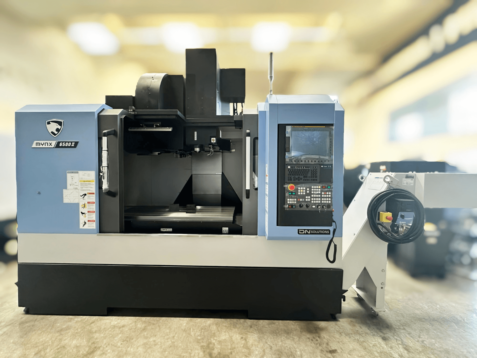 DN SOLUTIONS MYNX 6500 II vertical machining center in front view, featuring control panel and operational interface.
