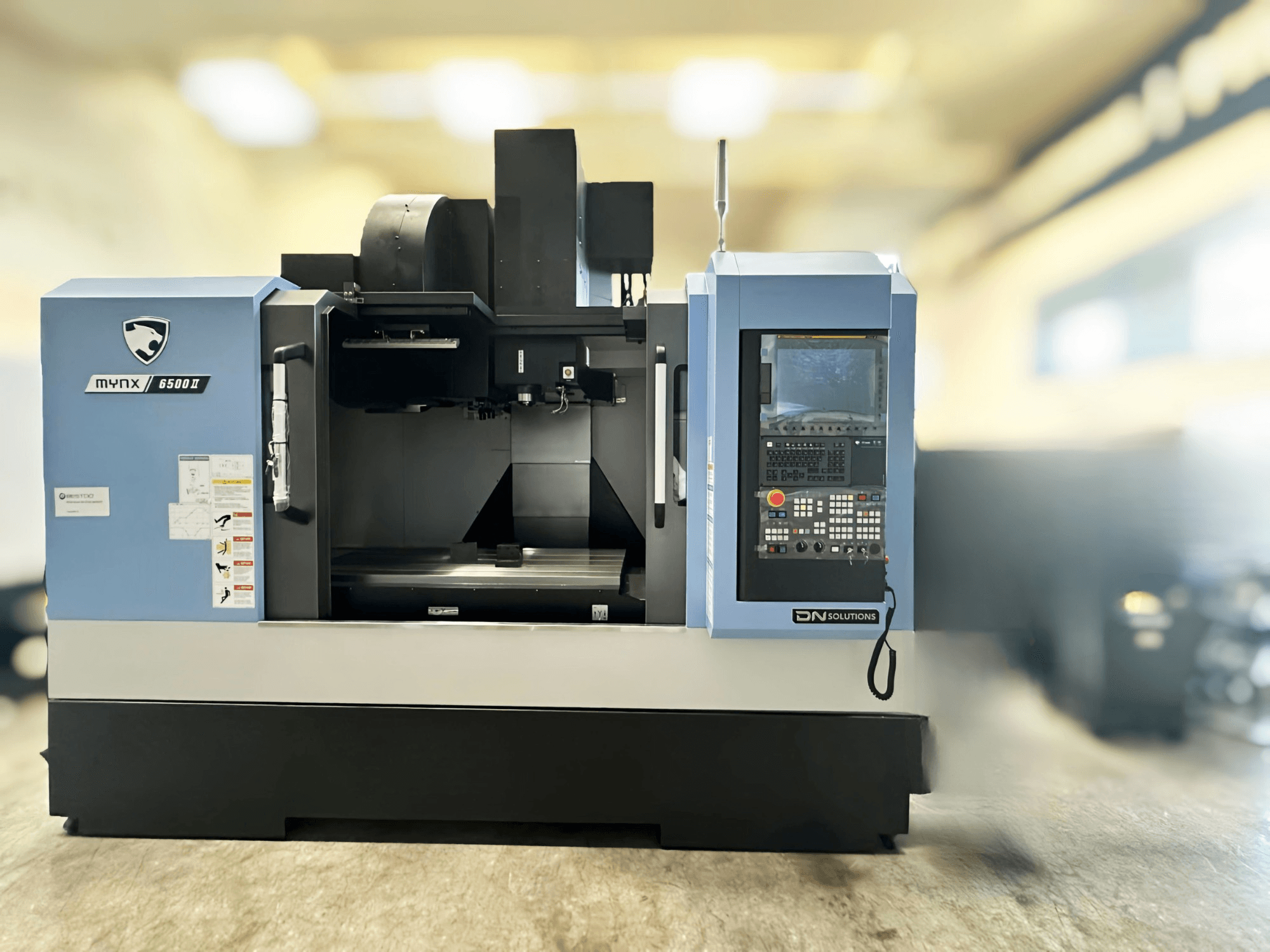 Vertical machining centre DN SOLUTIONS MYNX 6500 II, front view showcasing control panel and work area.