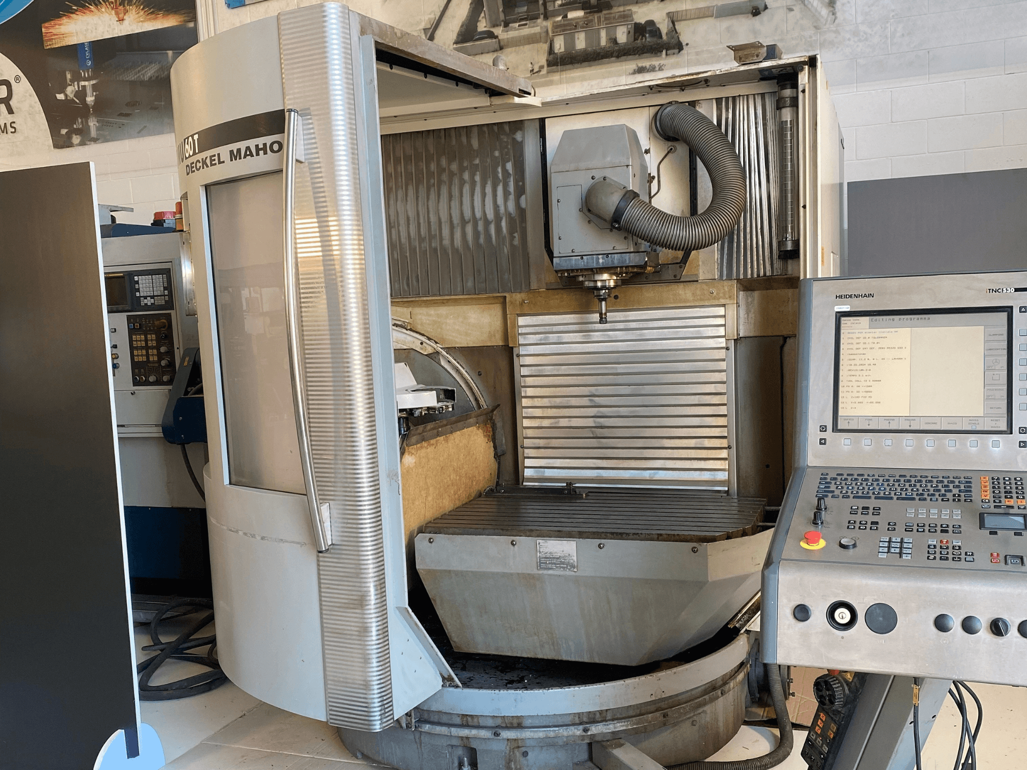 Front view of a DECKEL MAHO DMU 60T milling machine with a control panel, spindle, and milling table visible.