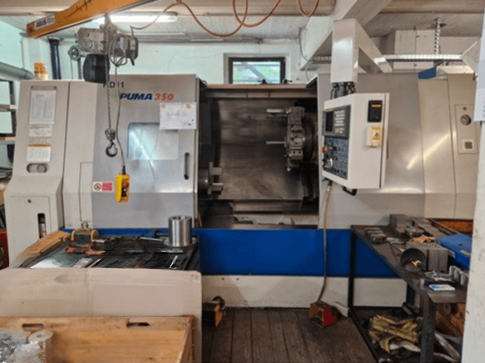 DAEWOO Puma 350 horizontal turning machine, side view, showcasing control panel and work area with tools and materials nearby.